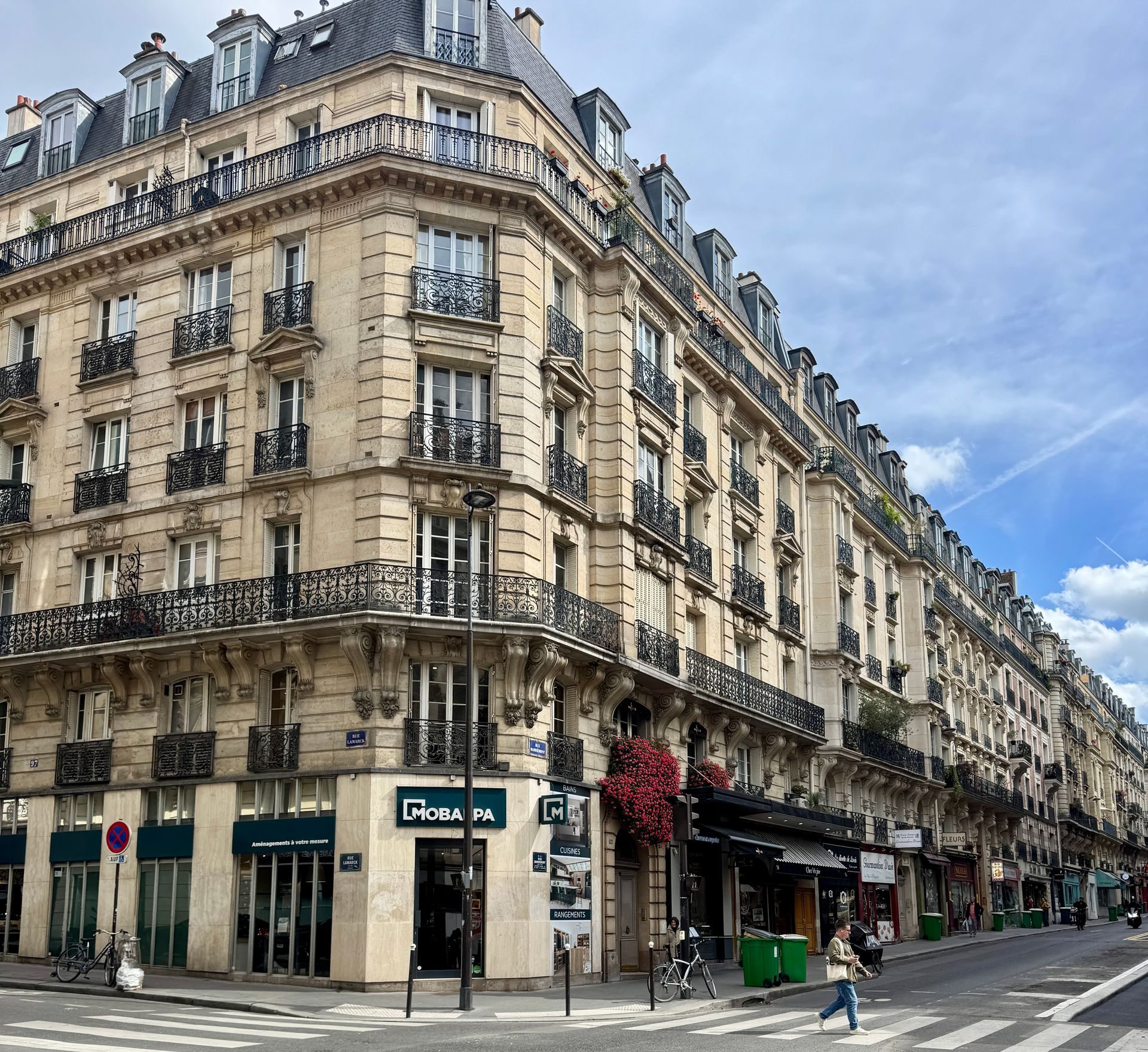 Corner building in Paris with shops at street level.