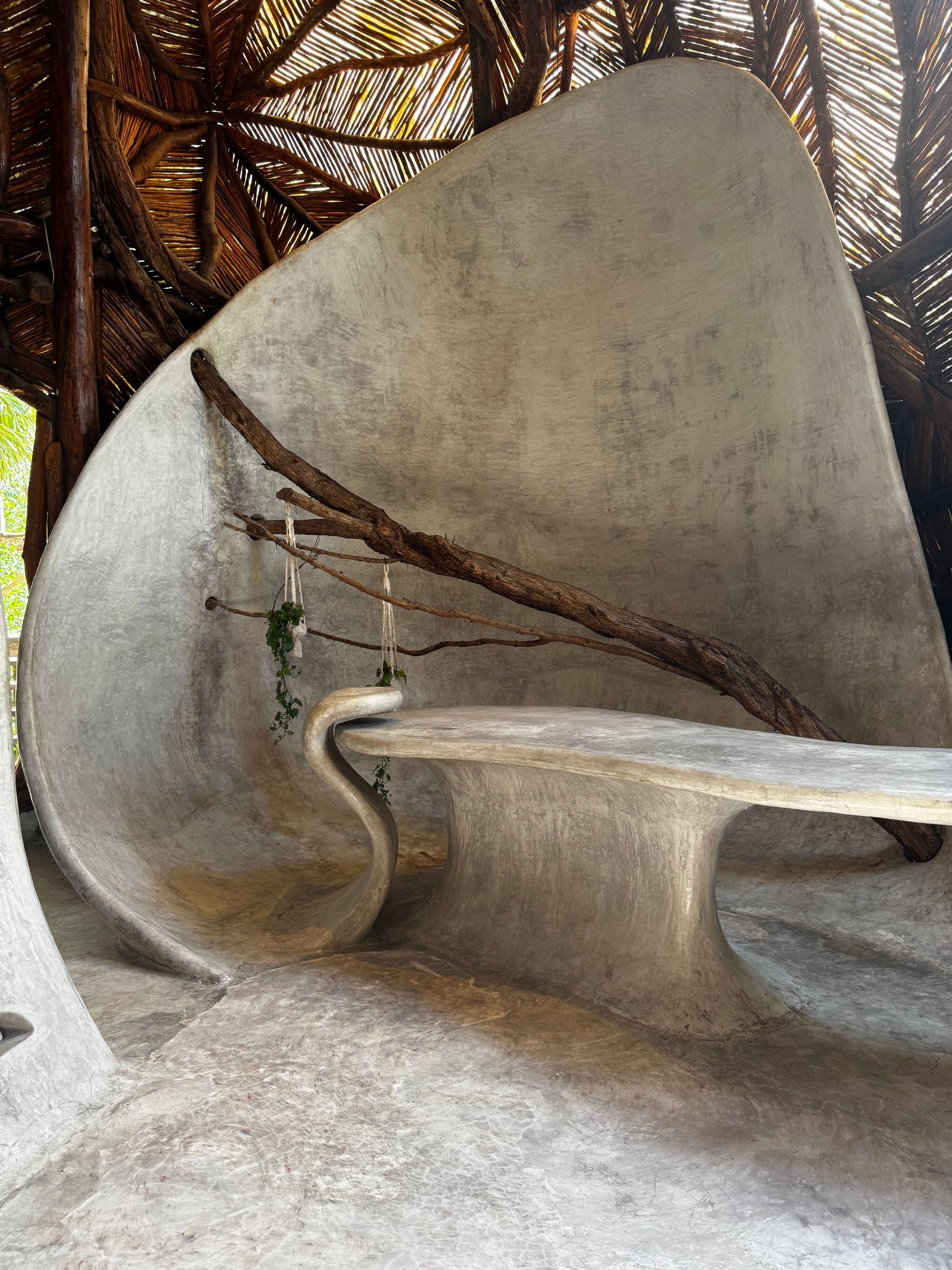 There is a bench in the middle of a concrete sculpture at Azulik Sfer Ik museum in Tulum, Mexico.