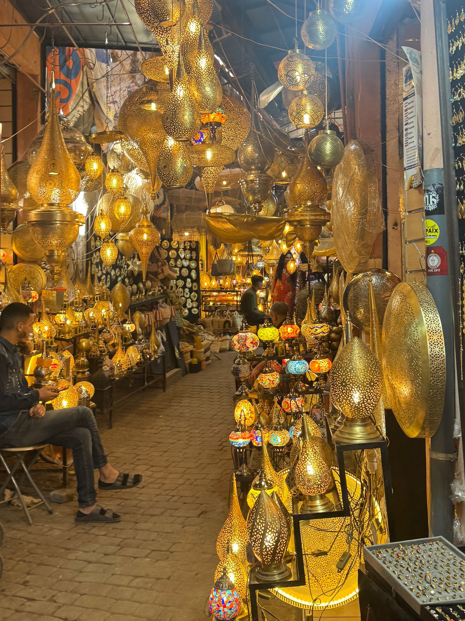 Golden lamps and lanterns in a crowded shop in the Souks of Marrakesh, Morocco.