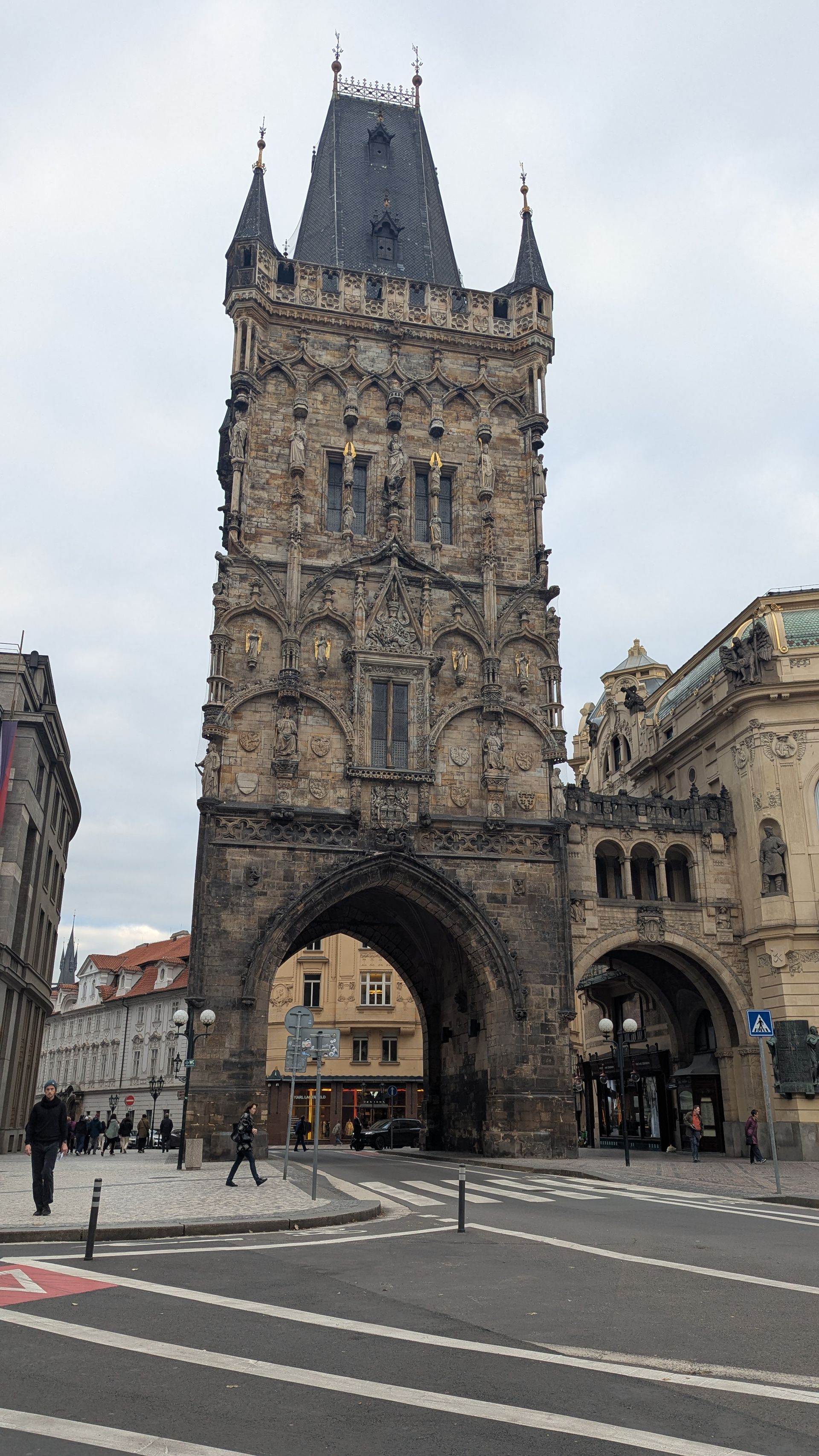 Powder Tower in Prague, Czech Republic. Gothic tower with arched entrance, on a city street.