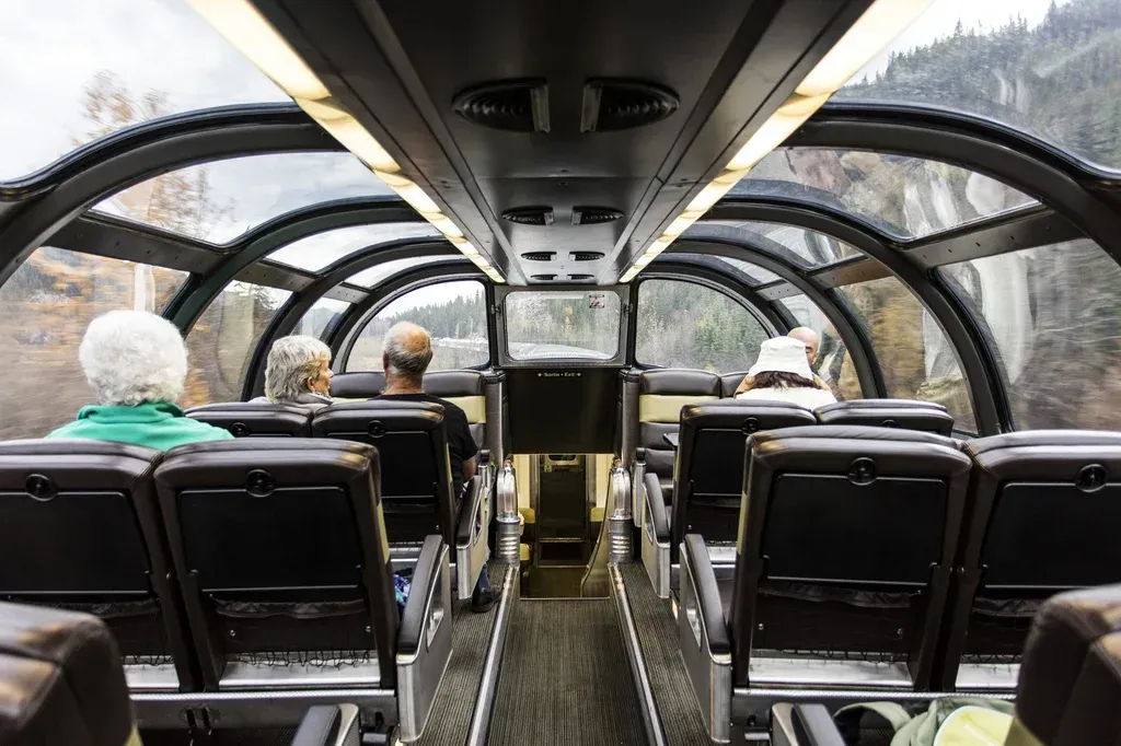 The inside of a Via Rail train with people sitting in the seats.