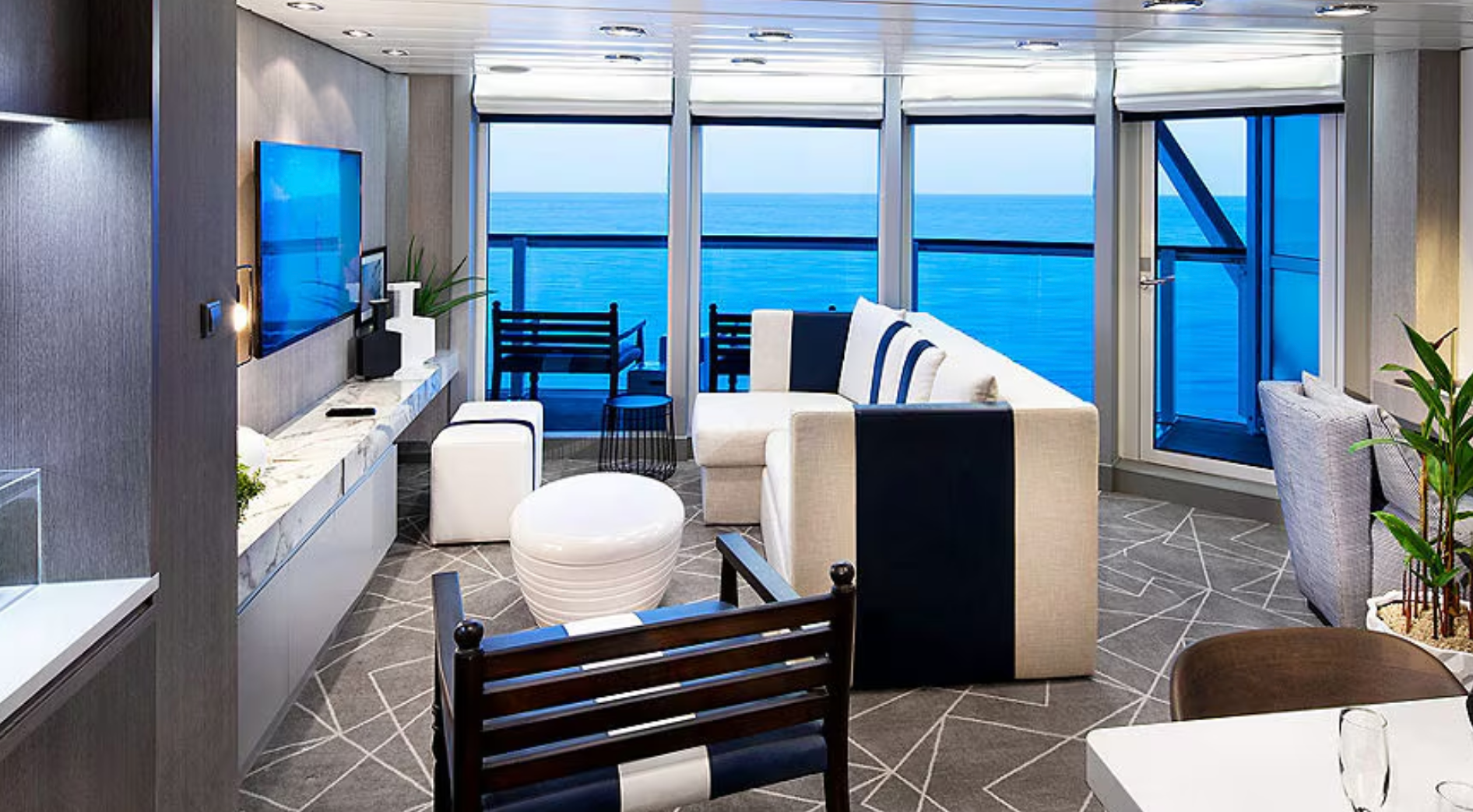 A living room on the Celebrity Summit cruise ship with a view of the ocean.