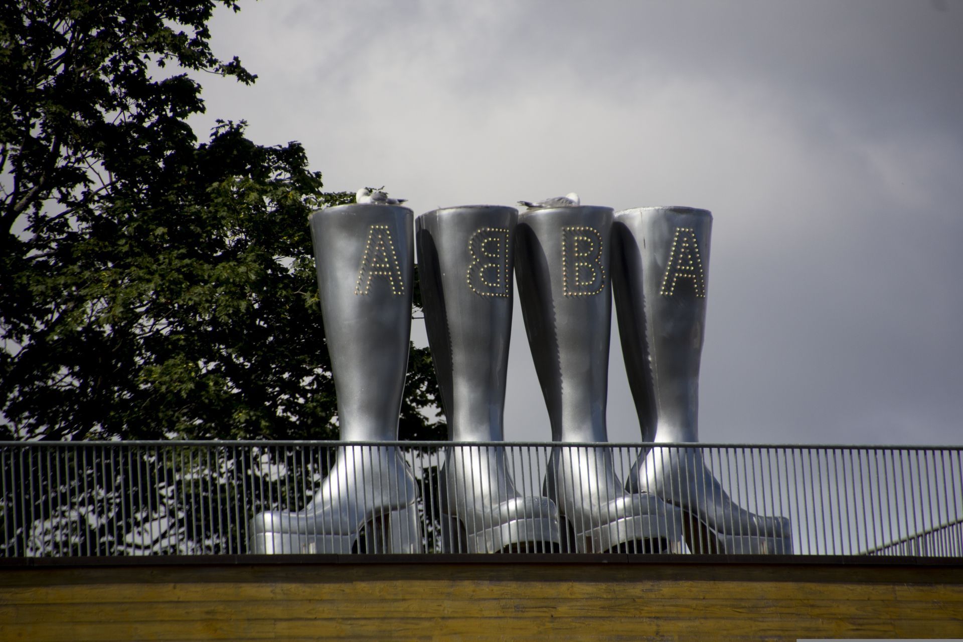 A row of silver boots with the letter s on them at the ABBA The Museum in Stockholm.