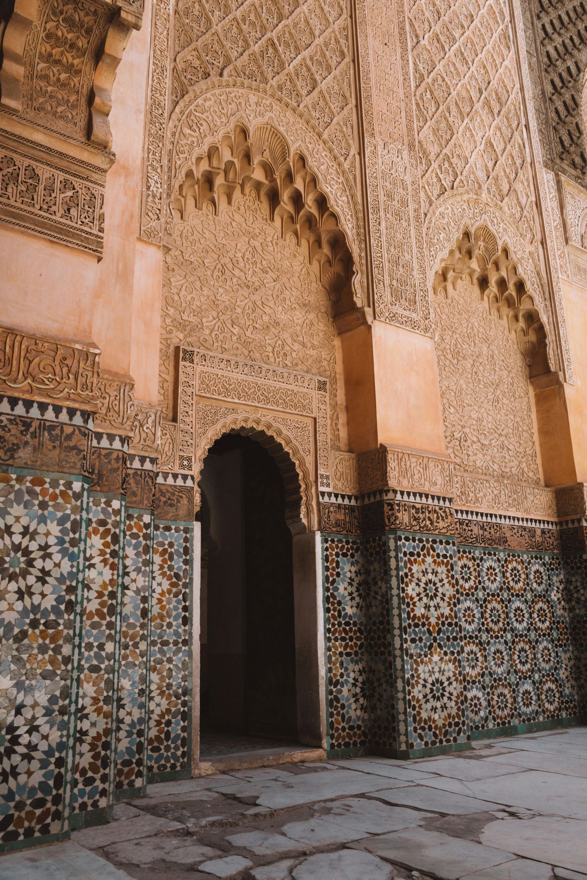 A doorway in a building with a mosaic wall and arches in Marrakesh, Morocco.