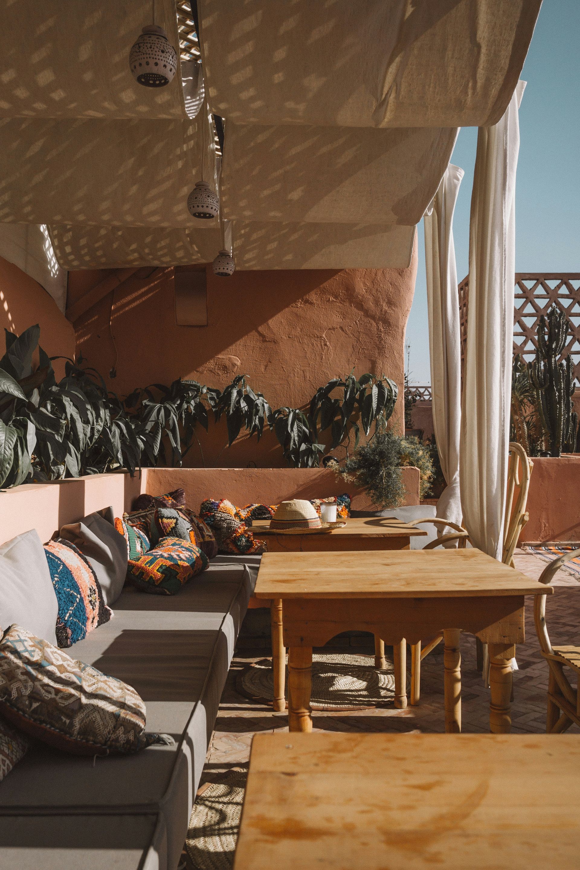 A patio with a couch , table and chairs under a canopy in Marrakesh, Morocco.