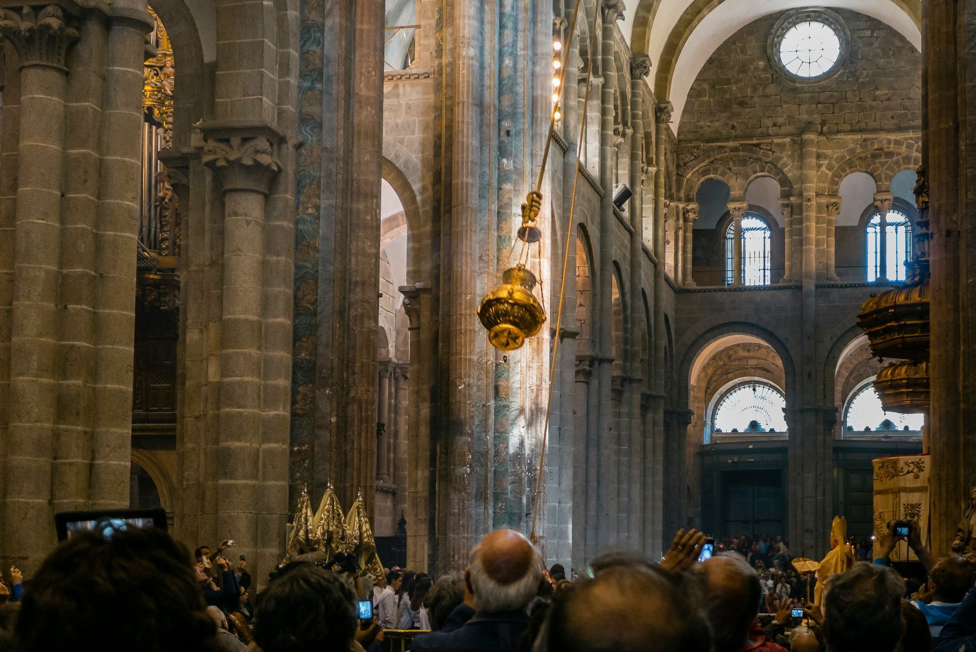 Interior of a cathedral: tall columns, arched windows, ornate chandelier in Santiago de Compostela, Spain.