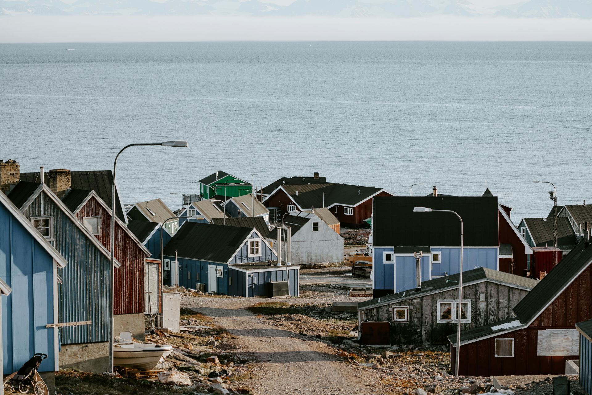 Colorful wooden houses on a rocky coast with a calm sea in the background in Ittoqqortoormiit, Greenland.