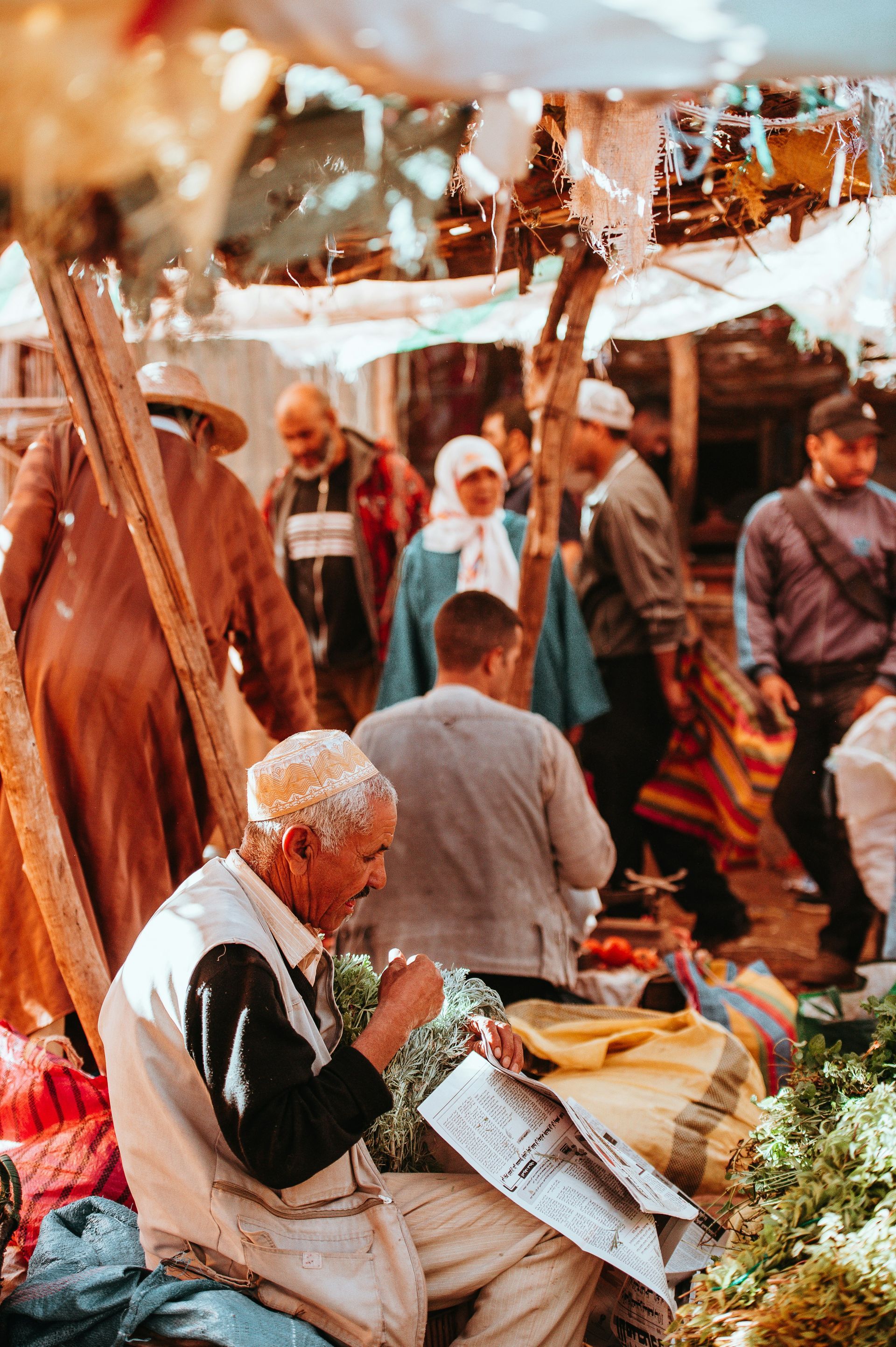 A man is sitting at a market selling vegetables in Marrakesh, Morocco.