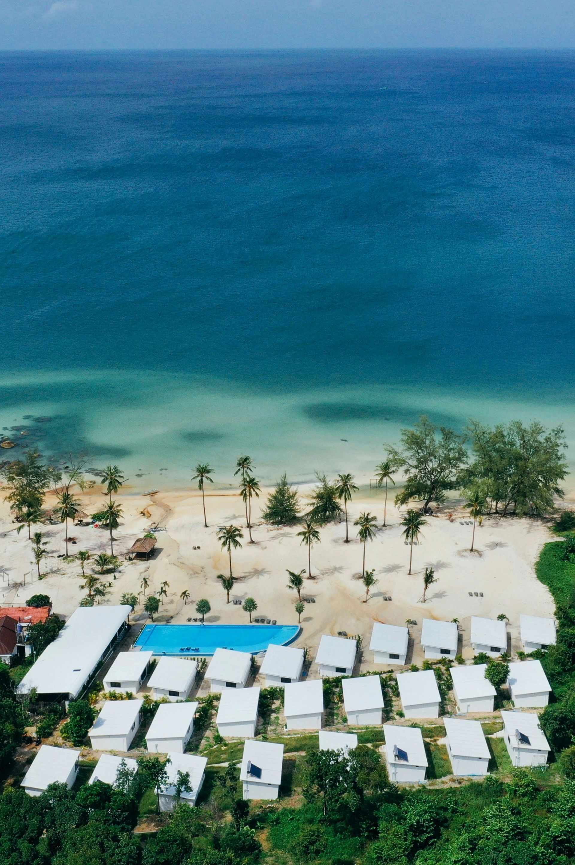 White bungalows and pool on a tropical beach in Koh Rong, Cambodia.