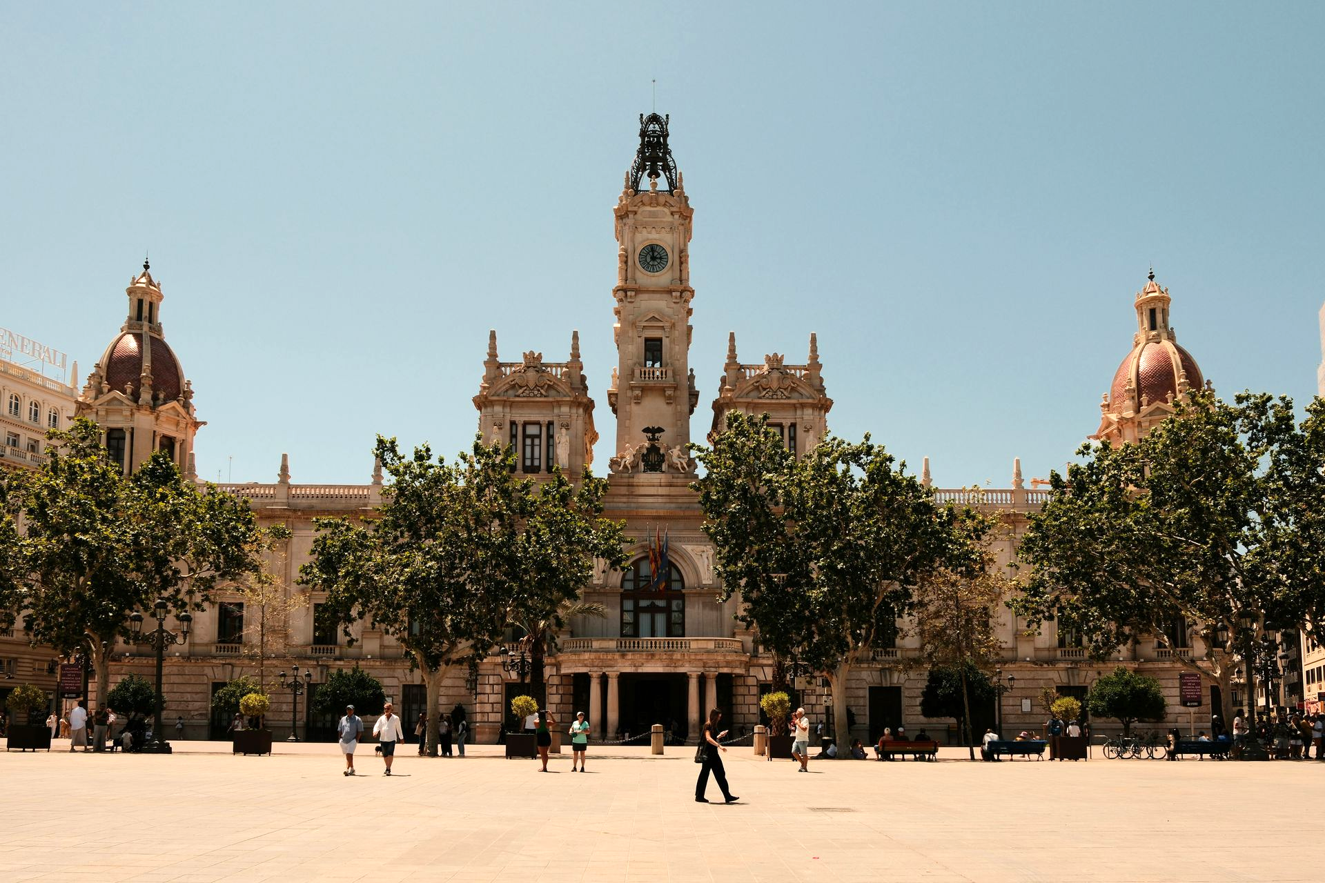 Valencia City Hall, Spain, a grand, ornate building with a clock tower, under a clear blue sky.