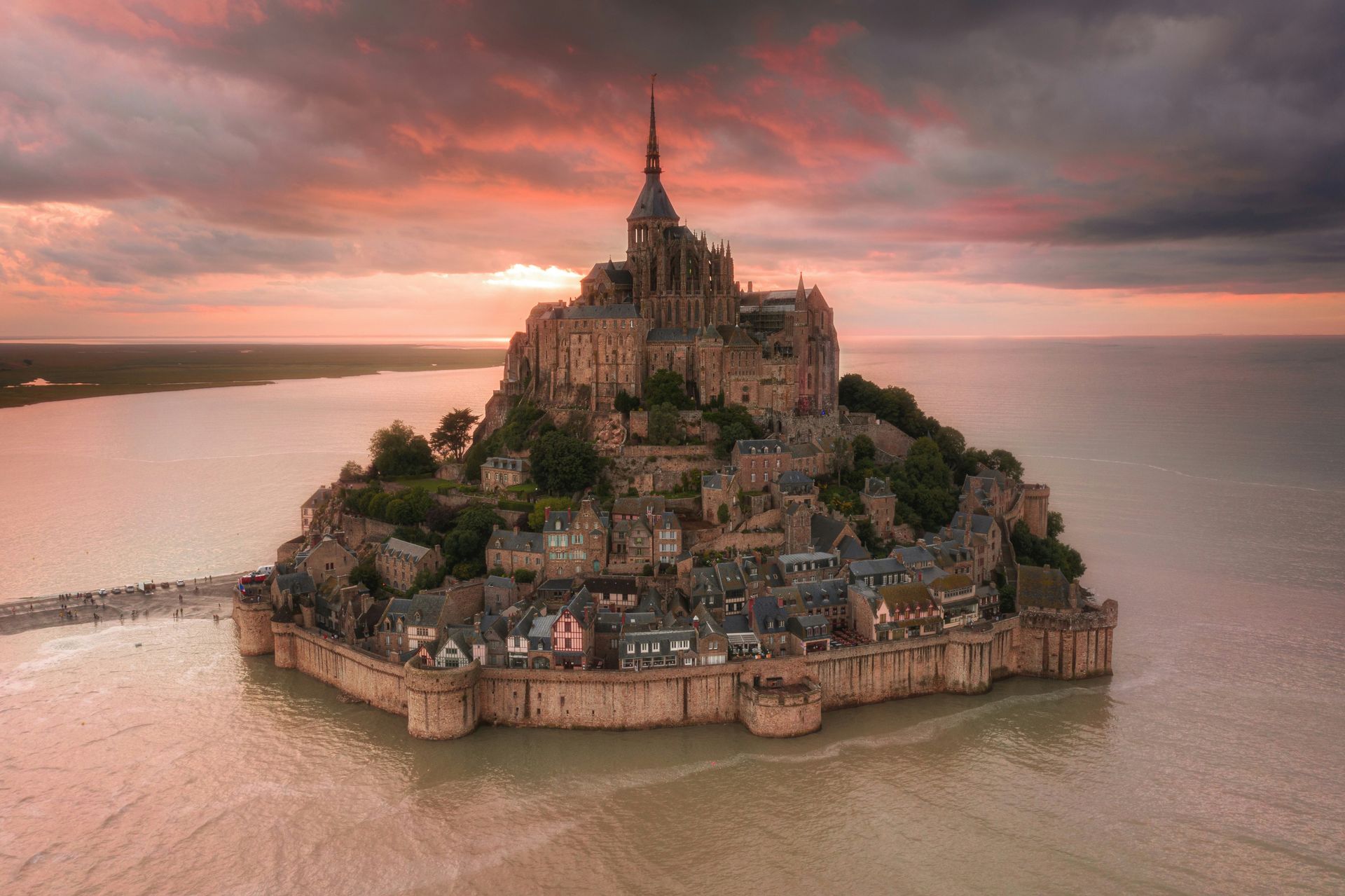 An aerial view of a small island in the middle of the ocean with Mont Saint-Michel on top in France.