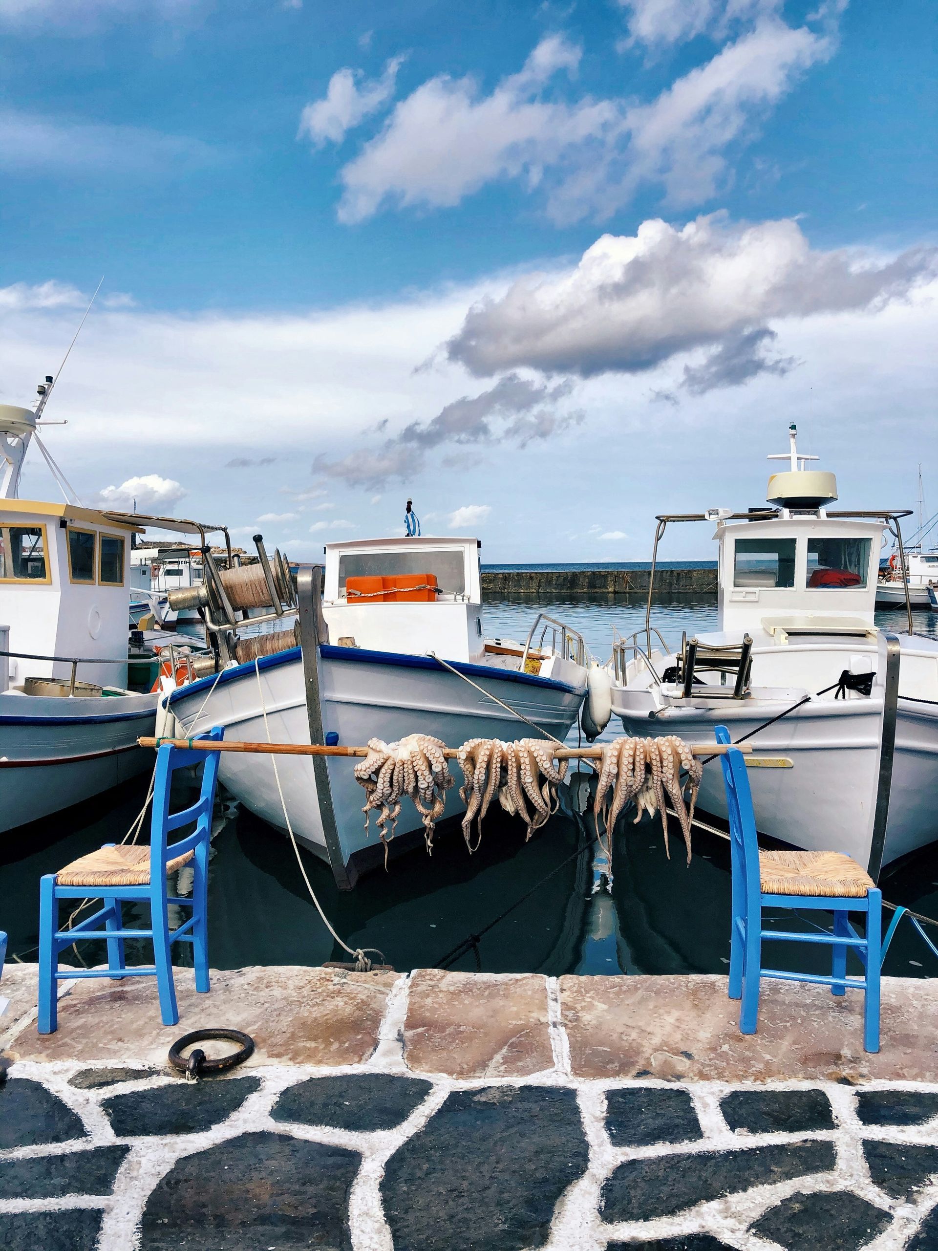 A row of boats are docked in Naousa harbor in Paros, Greece.