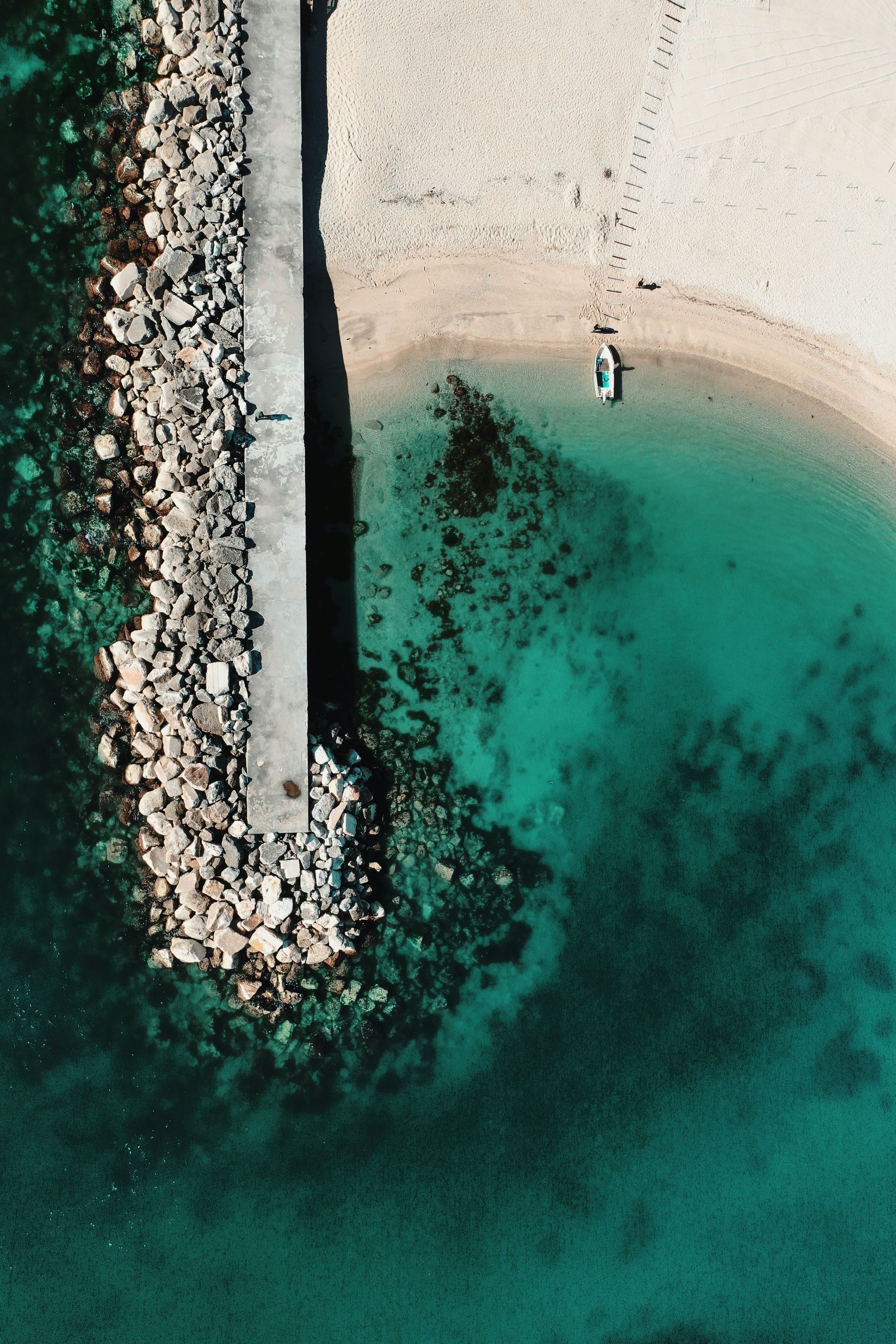 An aerial view of a beach with a boat in the water in Sirolo, Italy.