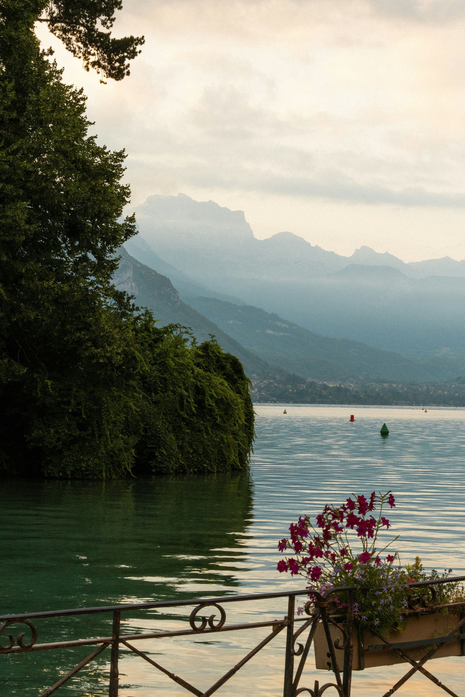 A fence overlooking Lake Annecy with mountains in the background in France. 