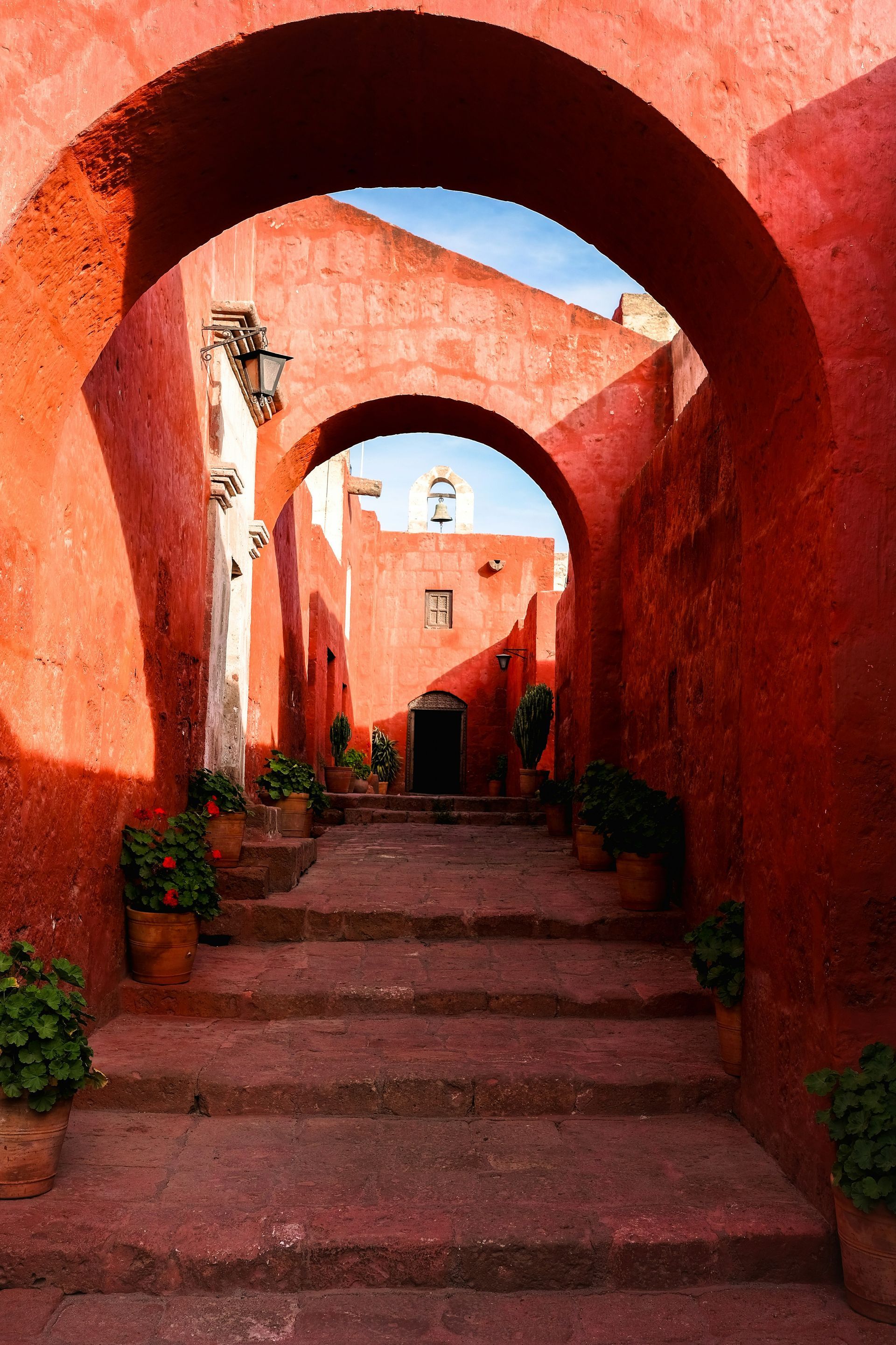 A narrow alleyway between two red buildings in Arequipa, Peru.