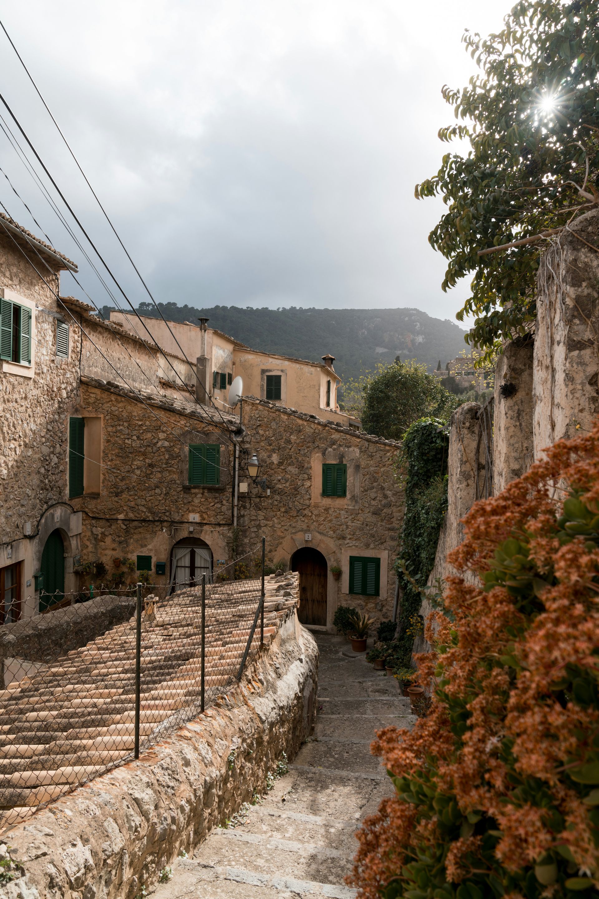 Stone buildings line a narrow cobblestone street in Majorca, Spain.