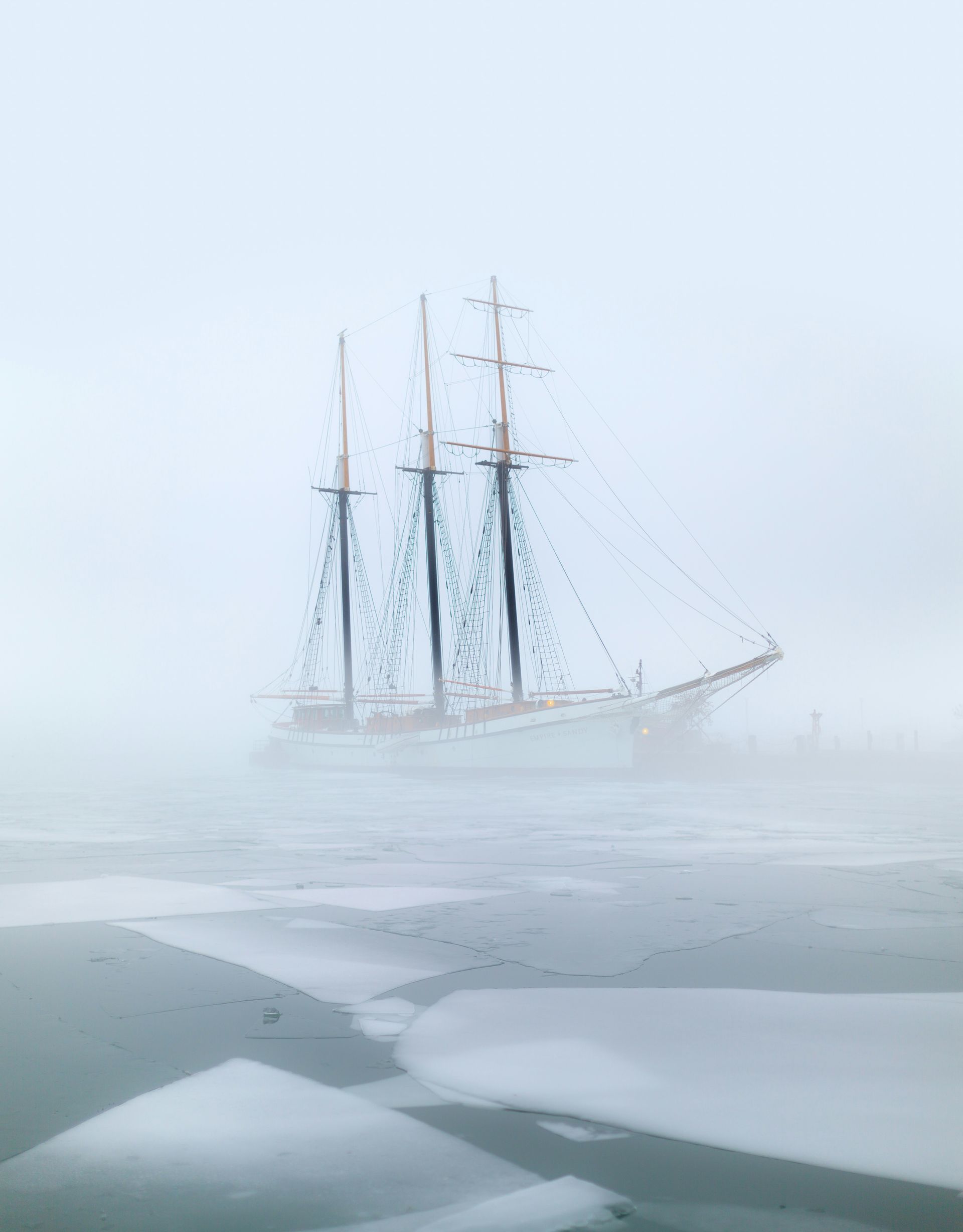 Sailing ship shrouded in dense fog and ice in the Northwest Passage, Canada.