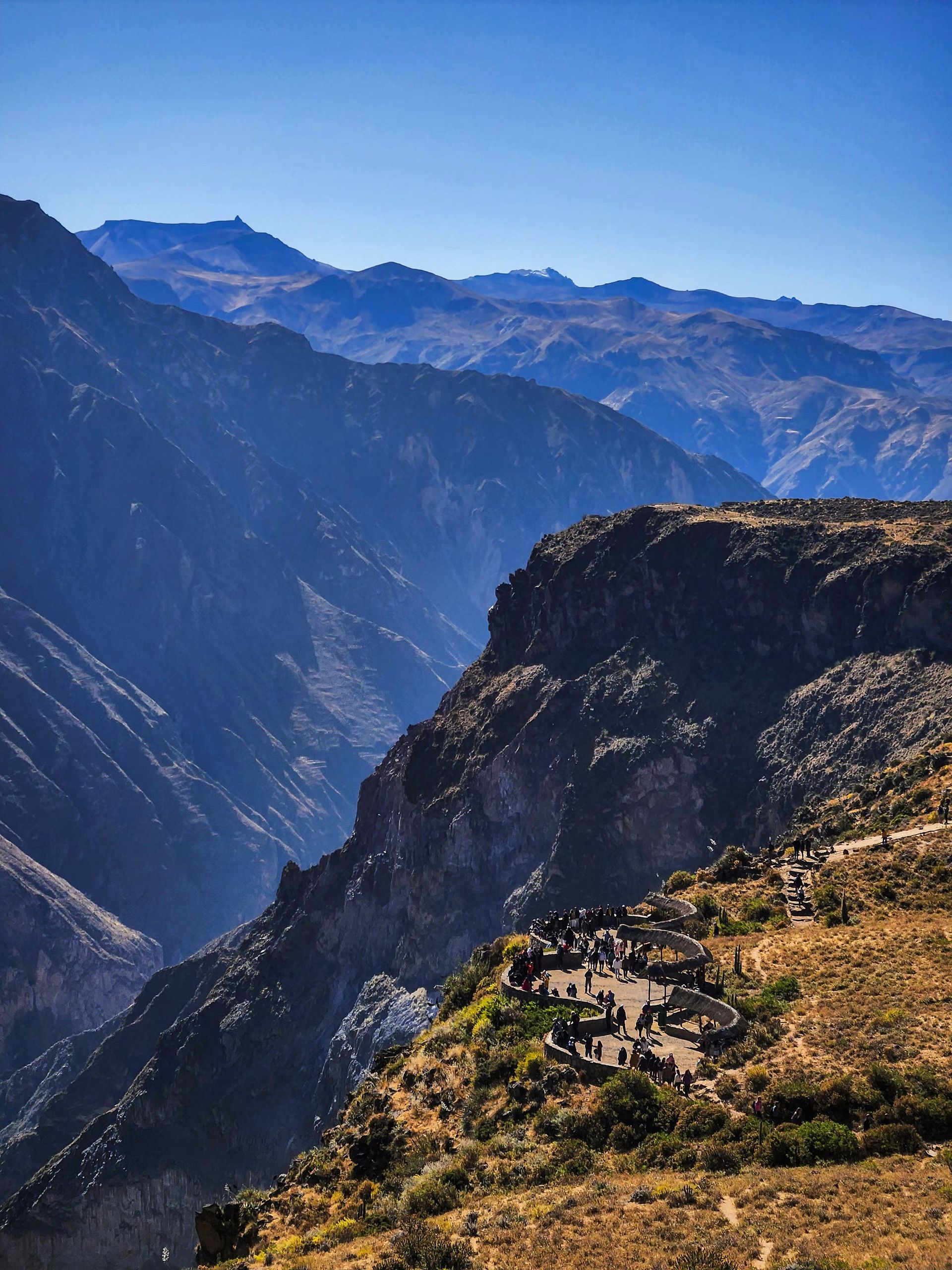 A group of people are standing on top of a mountain in the Colca Canyon, Peru.