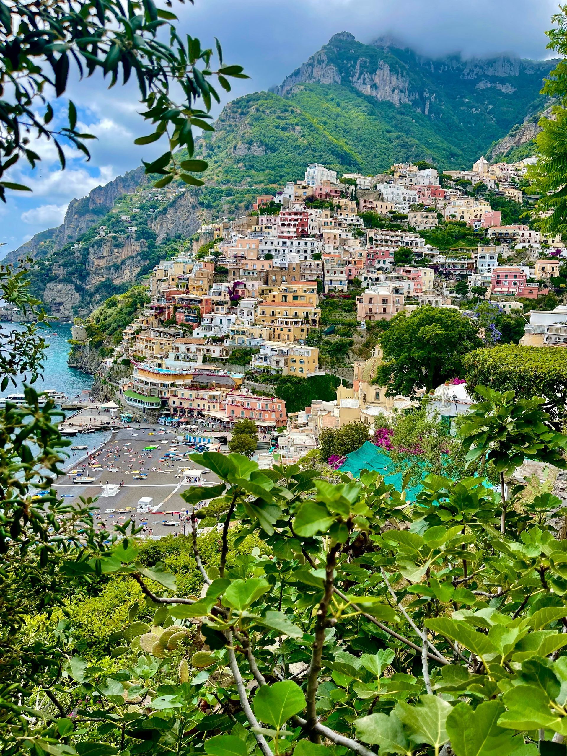 A view of a small town surrounded by mountains and trees on the Amalfi Coast.