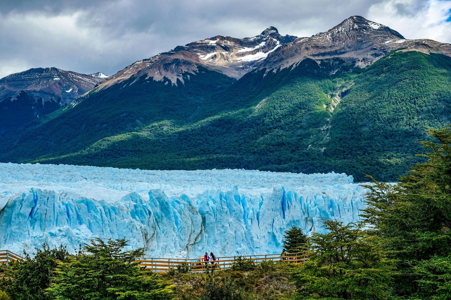 Glacier and snow-capped mountains in Patagonia, with green trees at Parque Nacional Los Glaciares in El Calafate, Argentina.