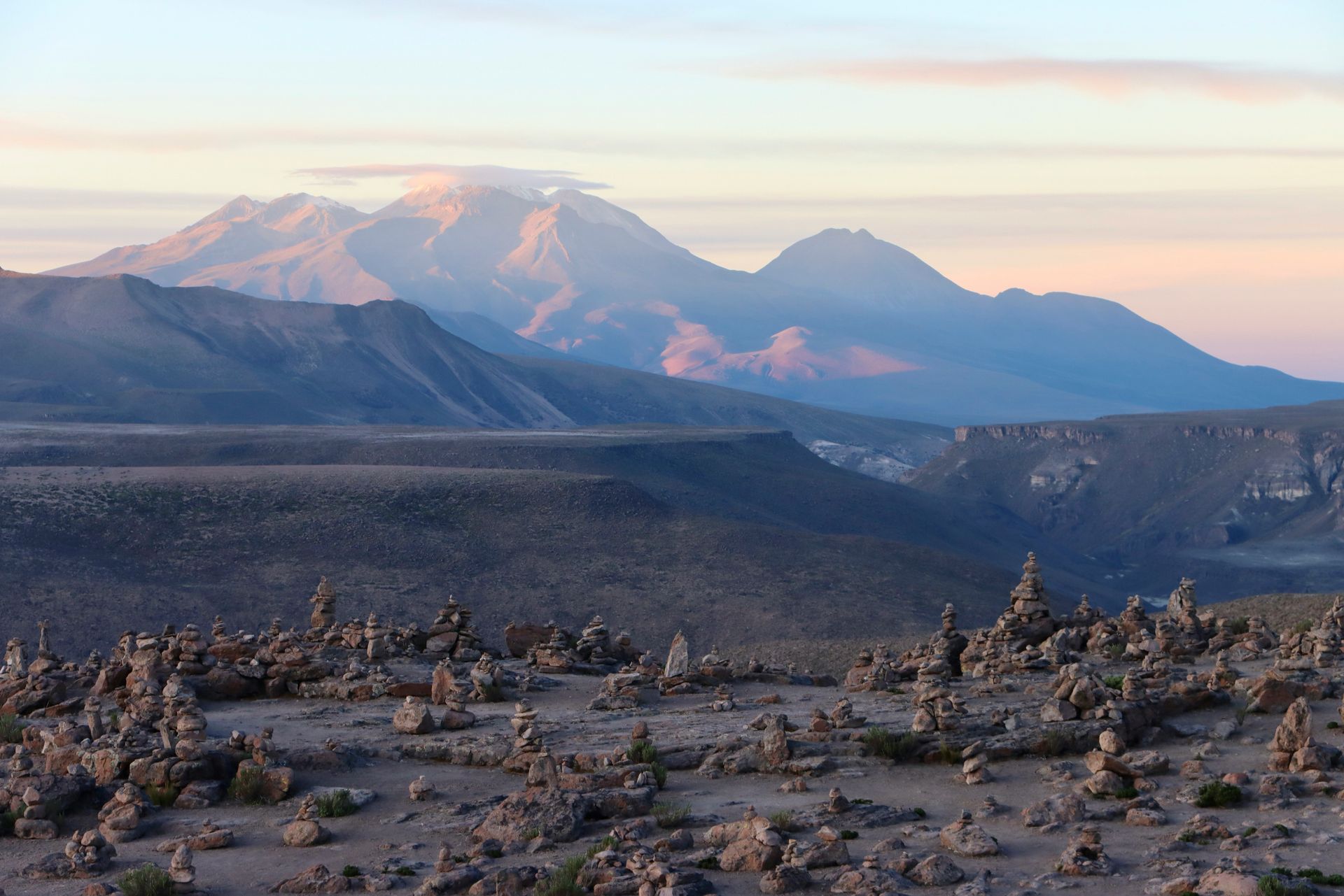 A desert landscape with mountains in the background and rocks in the foreground in the Colca Canyon, Peru.