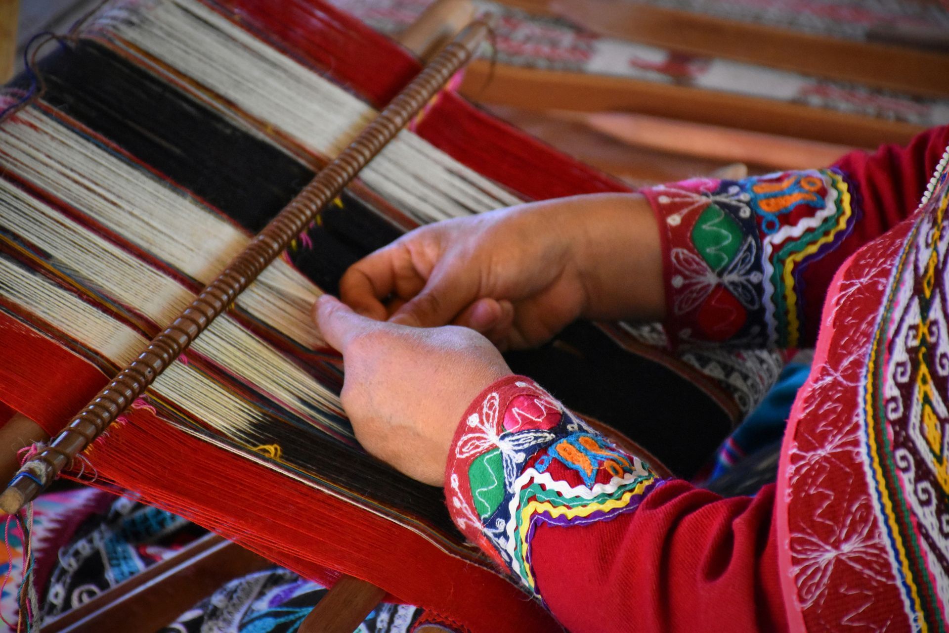 A woman is weaving a piece of fabric on a loom in Peru.