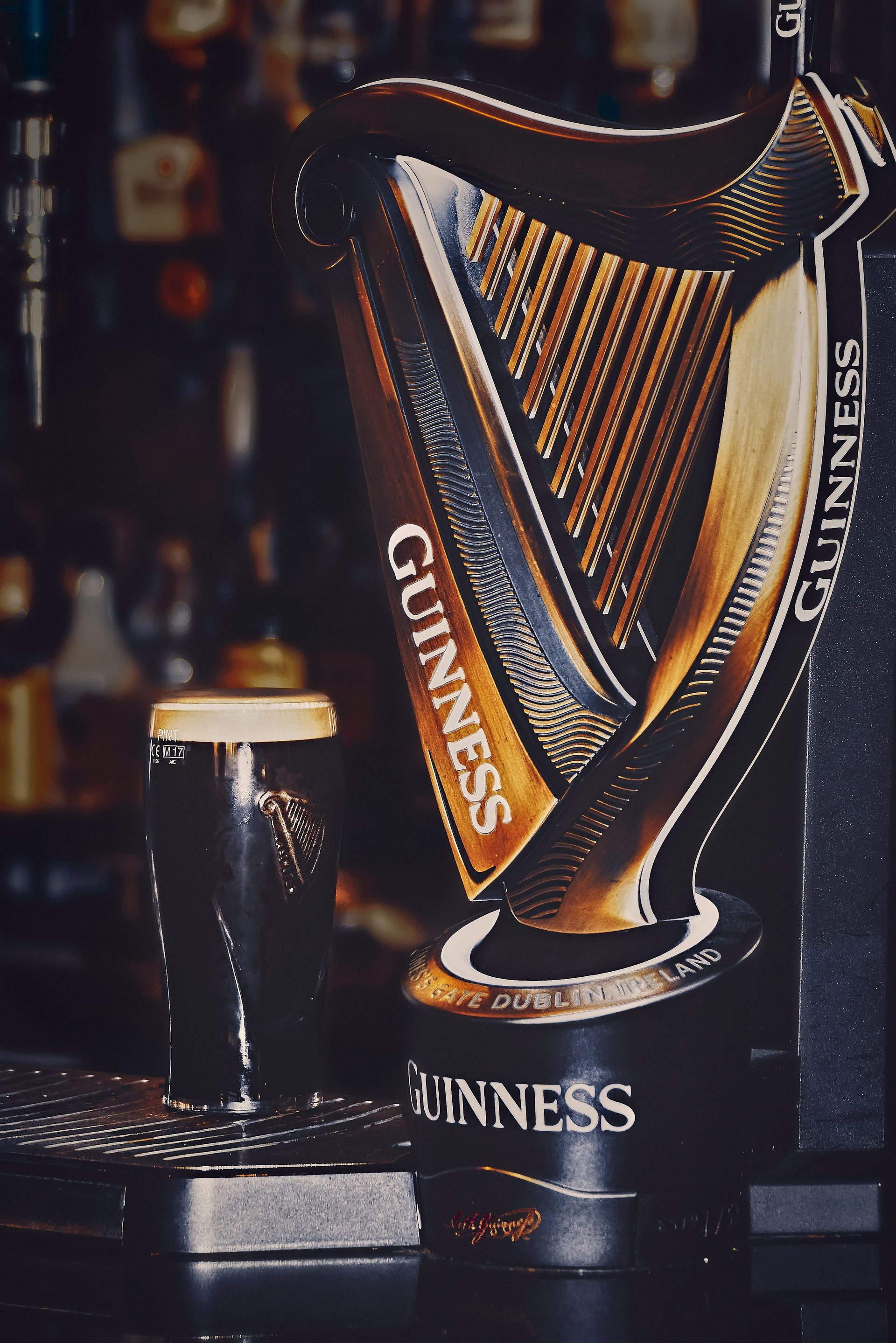 Guinness tap with a dark stout in a pub. The tap is a harp shape in Ireland.