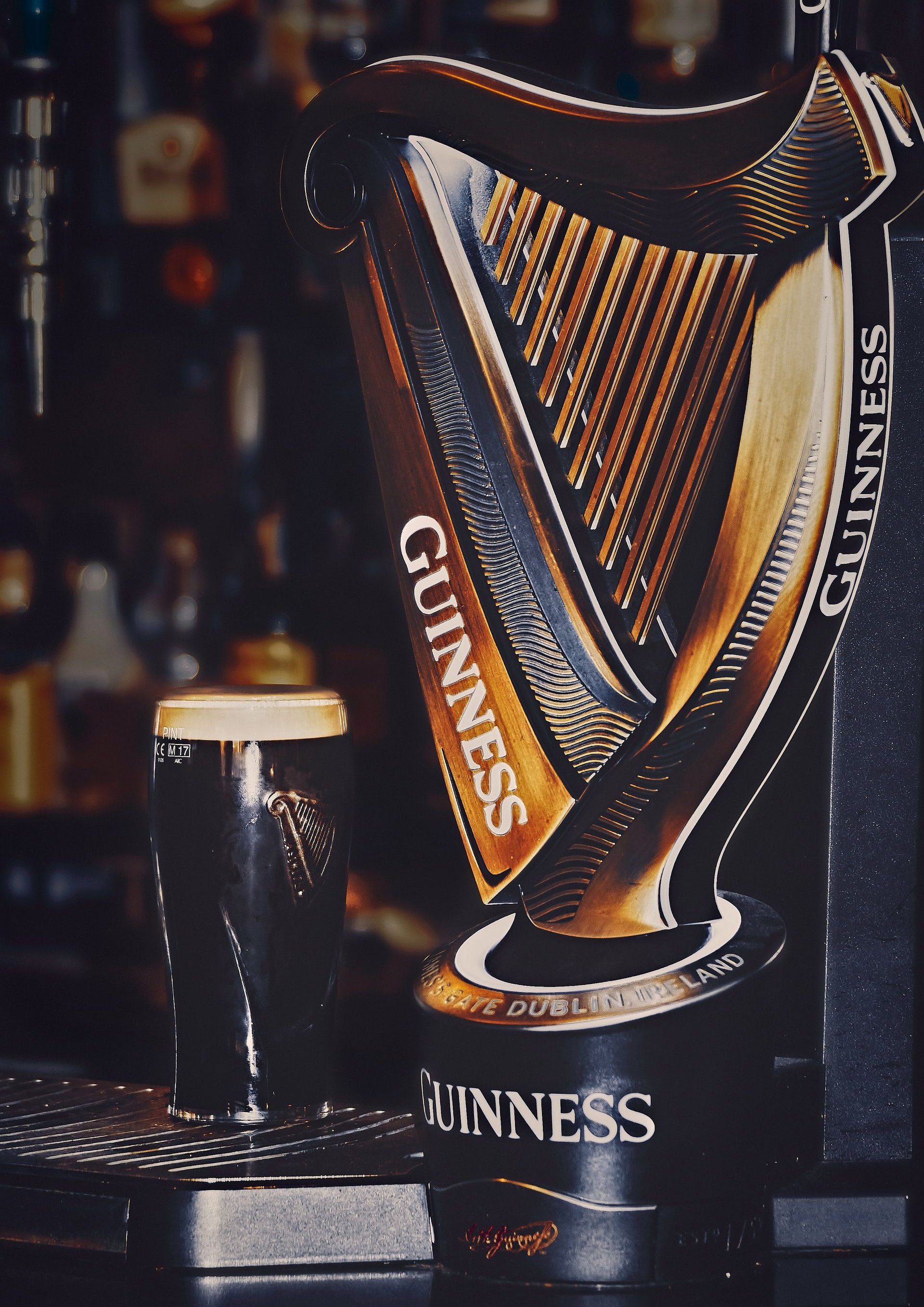 Guinness tap with a dark stout in a pub. The tap is a harp shape in Ireland.