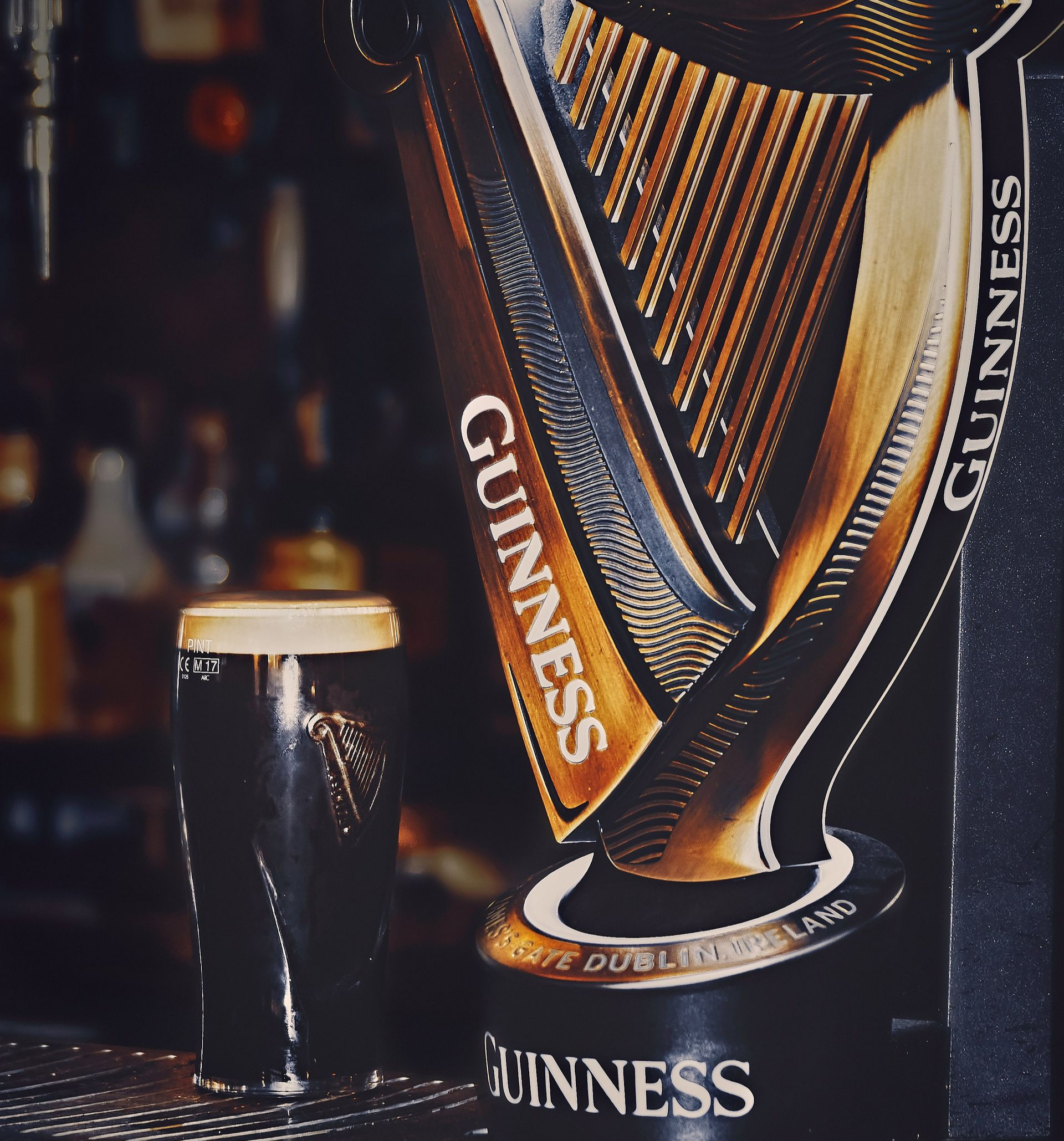 Guinness tap with a dark stout in a pub. The tap is a harp shape in Ireland.