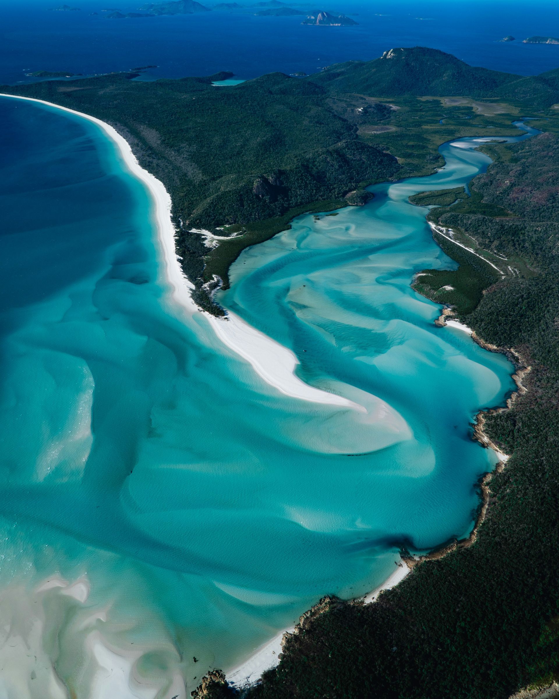 An aerial view of a beach with a river running through it in Darwin, Australia.