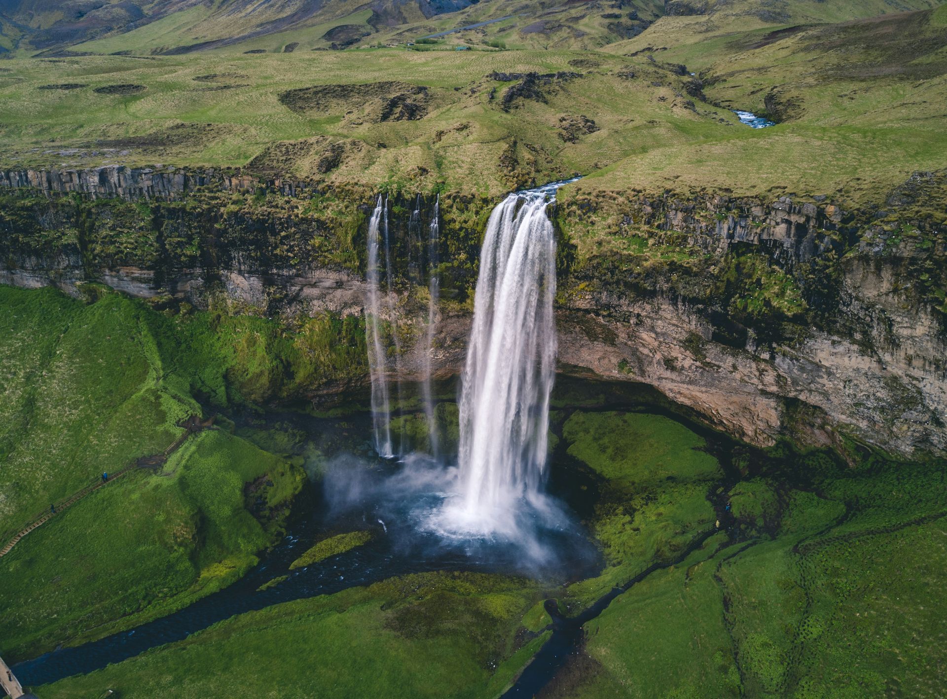 The Seljalandsfoss Waterfall cascading down a cliff into a lush green valley, Iceland.