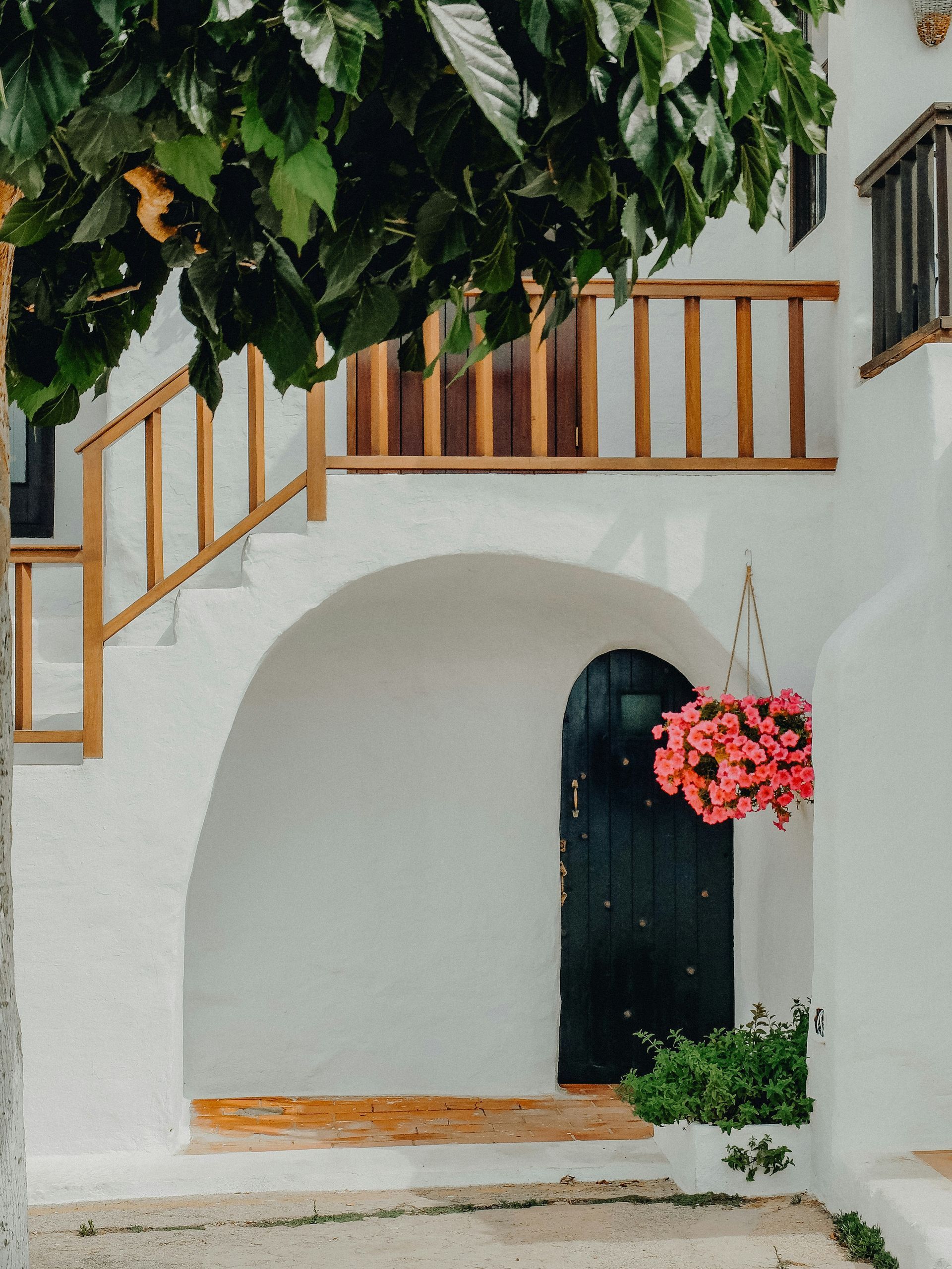 A white building with a black door and stairs in Menorca Spain.
