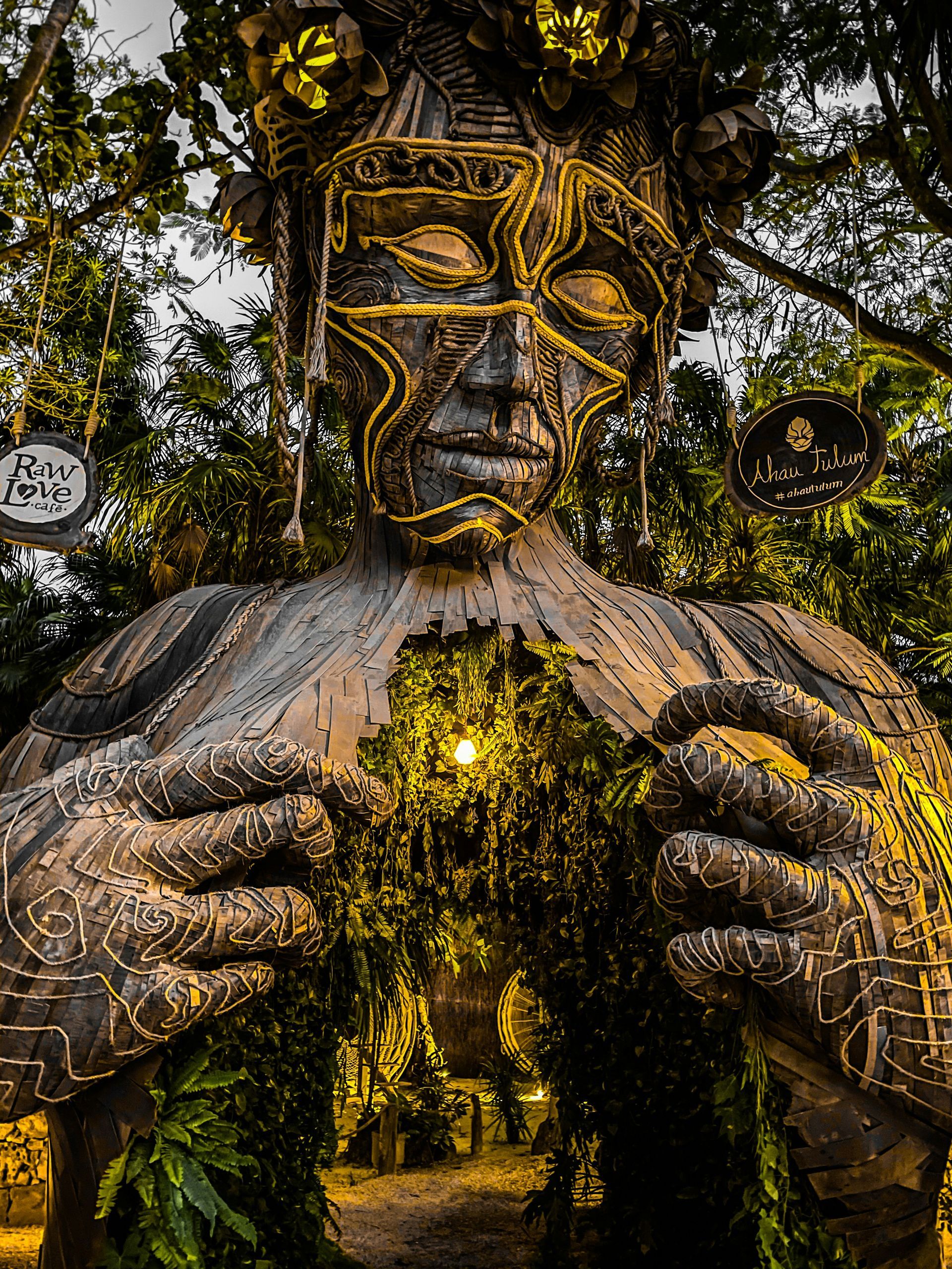 Sculpted figure of a person with a hollow torso, revealing a bright interior passageway in Tulum, Mexico.