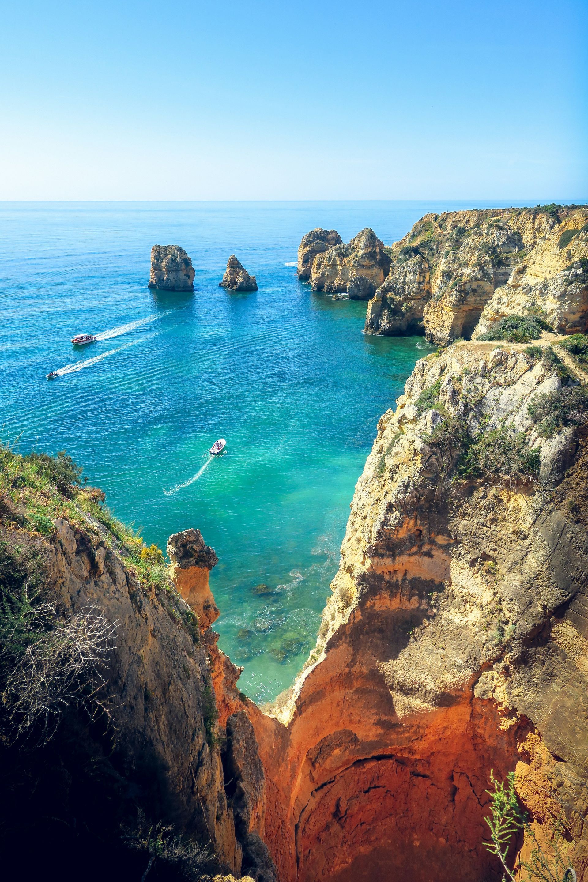 Rocky coastline with turquoise water, several rock formations in the sea in The Algarve, Portugal.