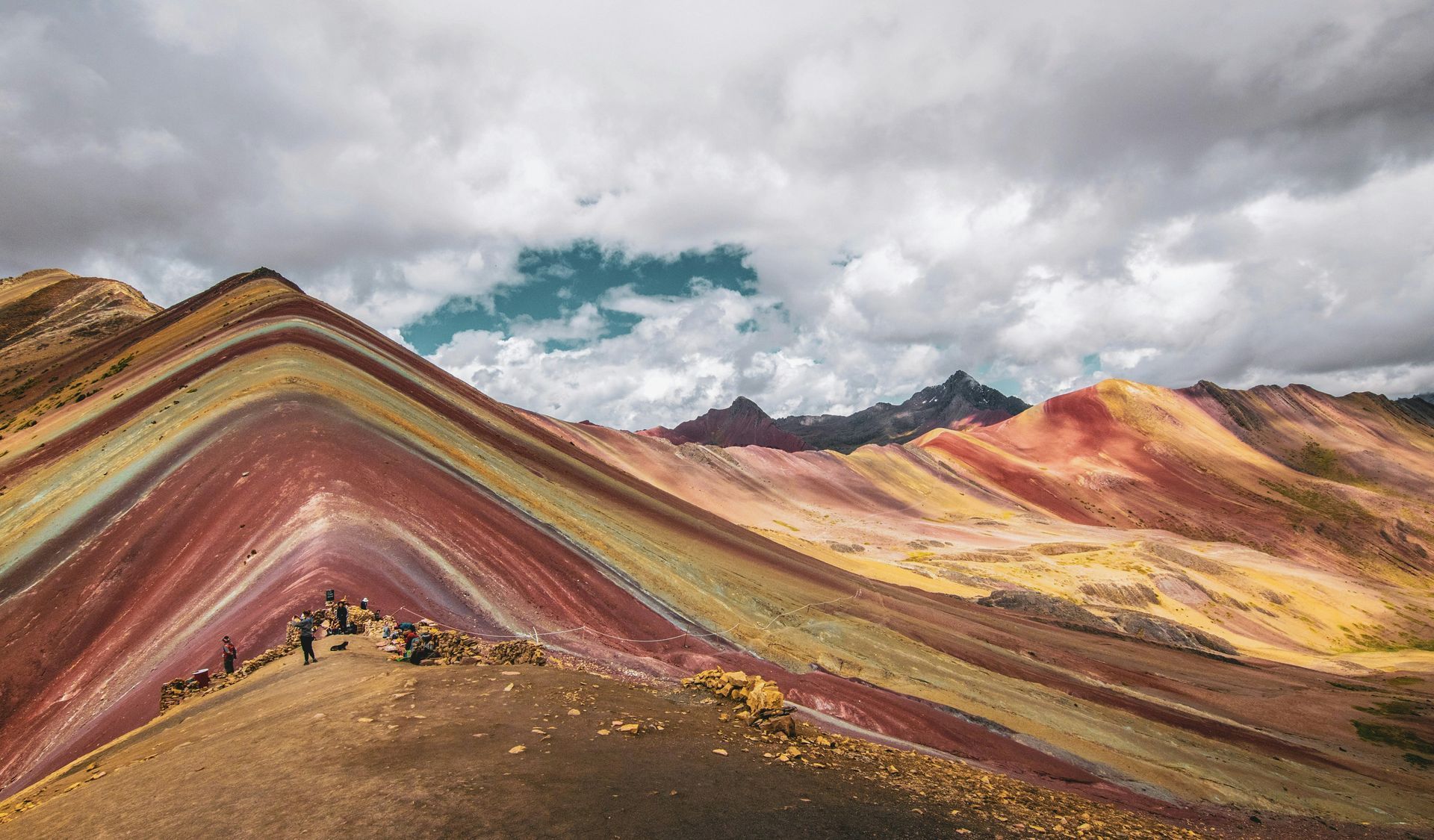 The rainbow mountains of Vinicunca, Peru with clouds above.