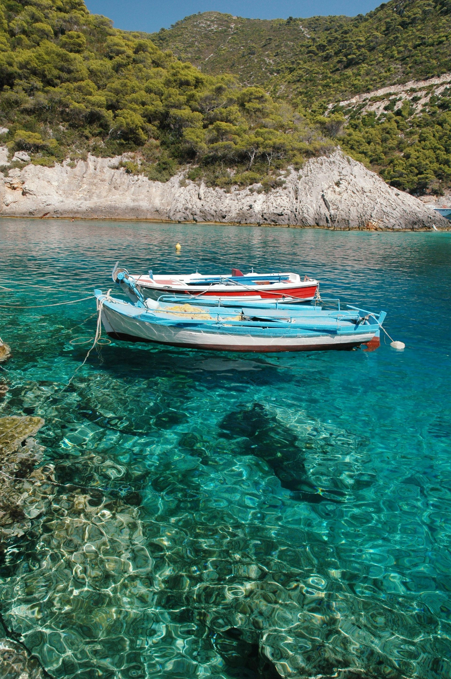 A couple of boats are floating on top of a body of water in Zakynthos, Greece.
