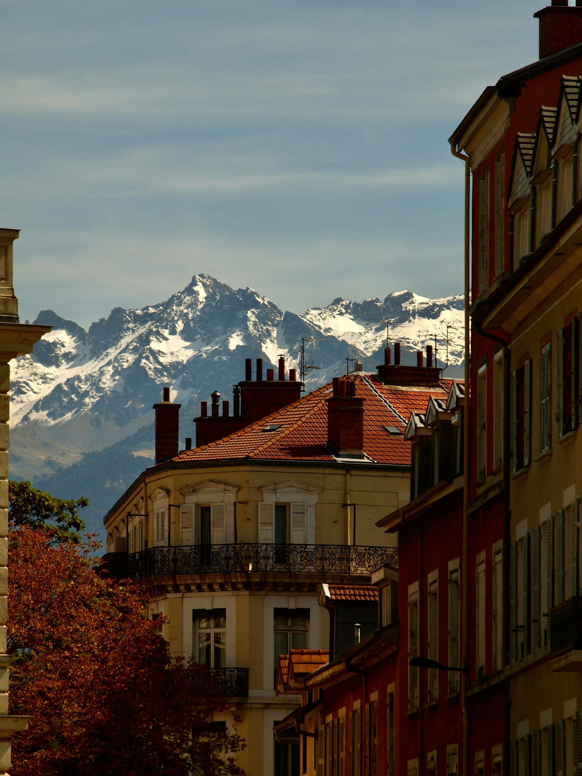 A row of buildings with mountains in the background in Grenoble, France.