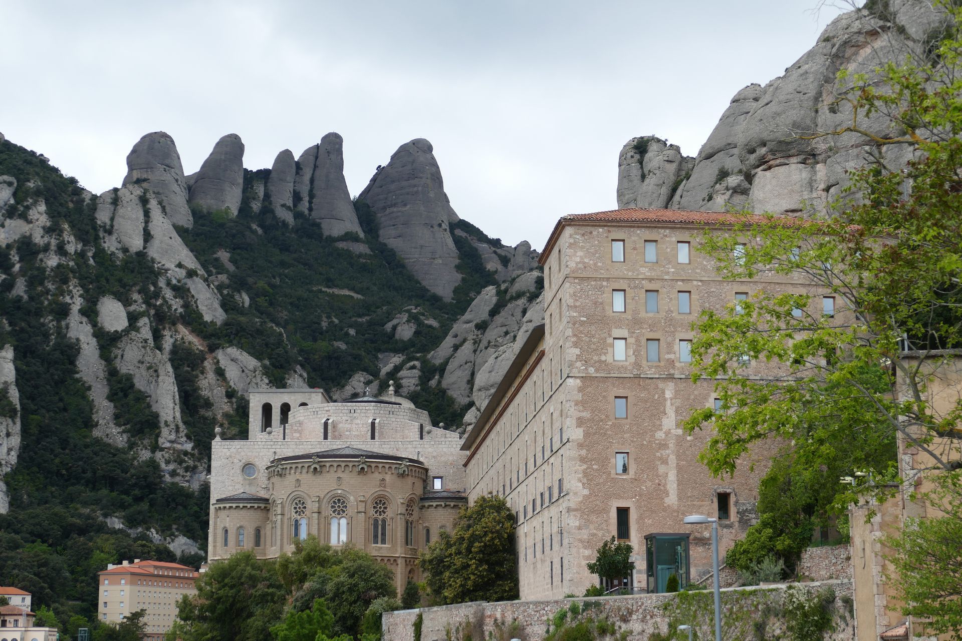 A large building with a mountain of Montserrat in the background in Spain.