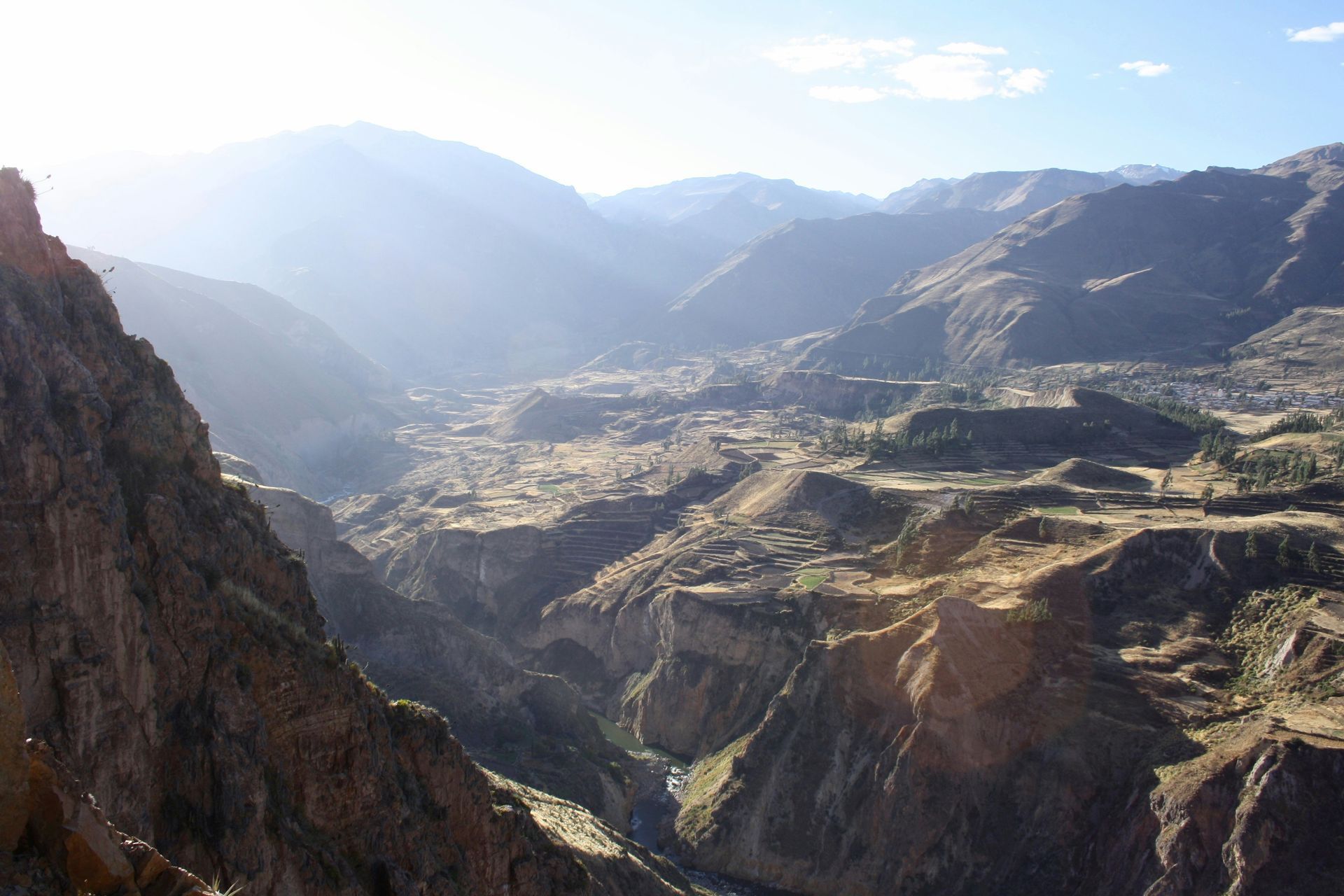 A view of the Colca Canyon with mountains in the background in Peru.