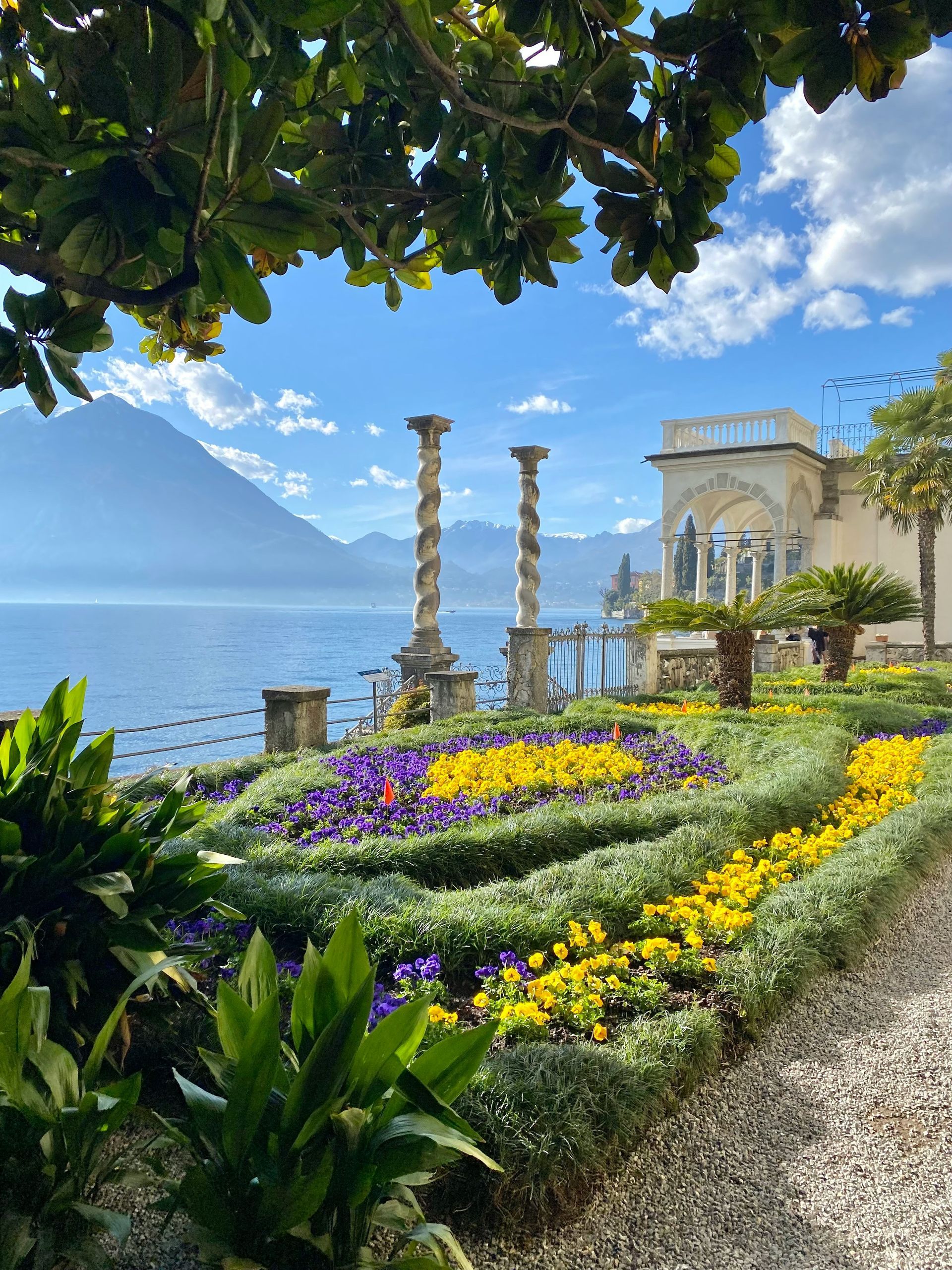 A garden with flowers and a building in the background on Lake Como, Italy.