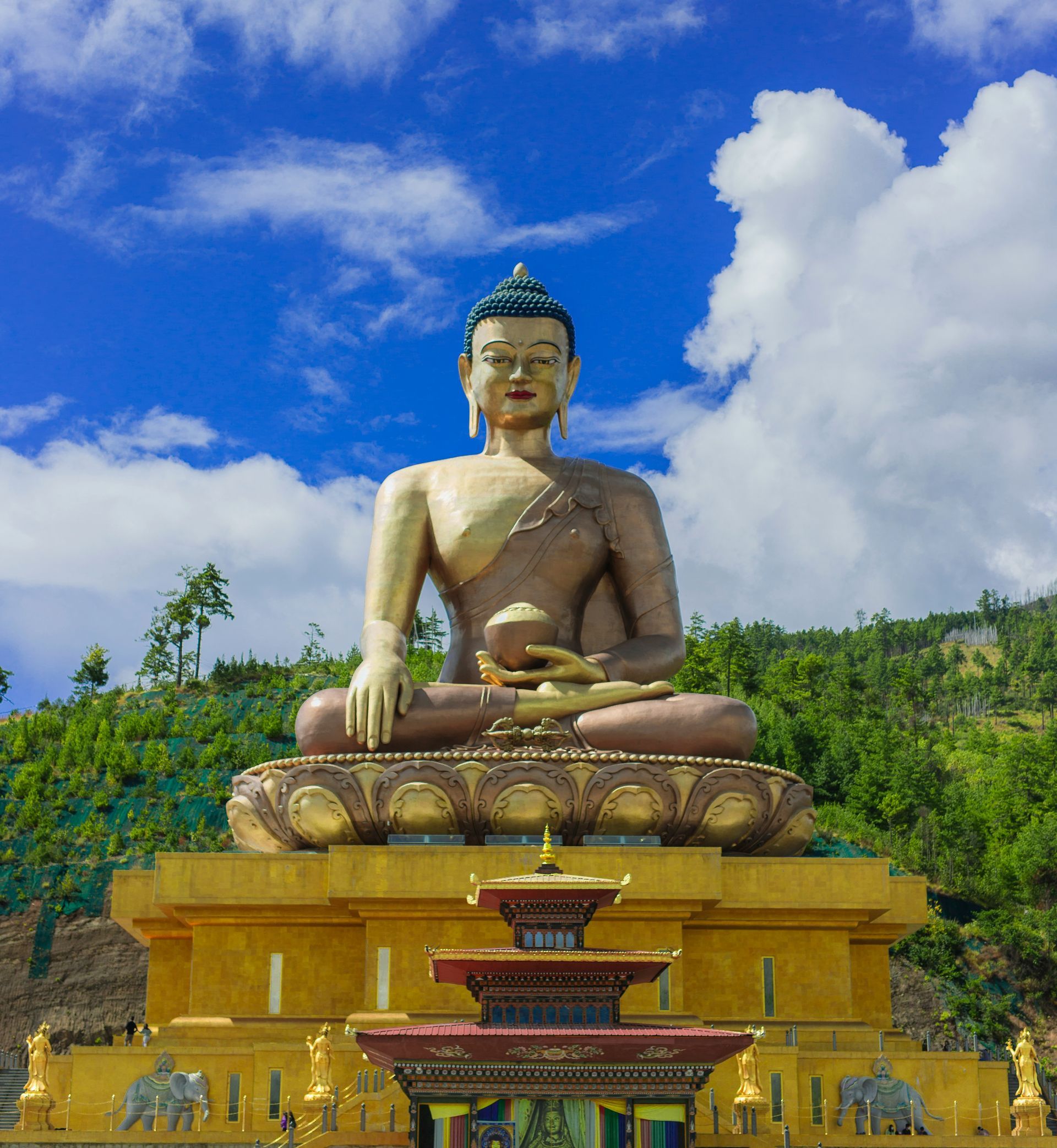 The giant golden Buddha Dordenma statue sits atop a yellow platform in Thimphu, Bhutan.
