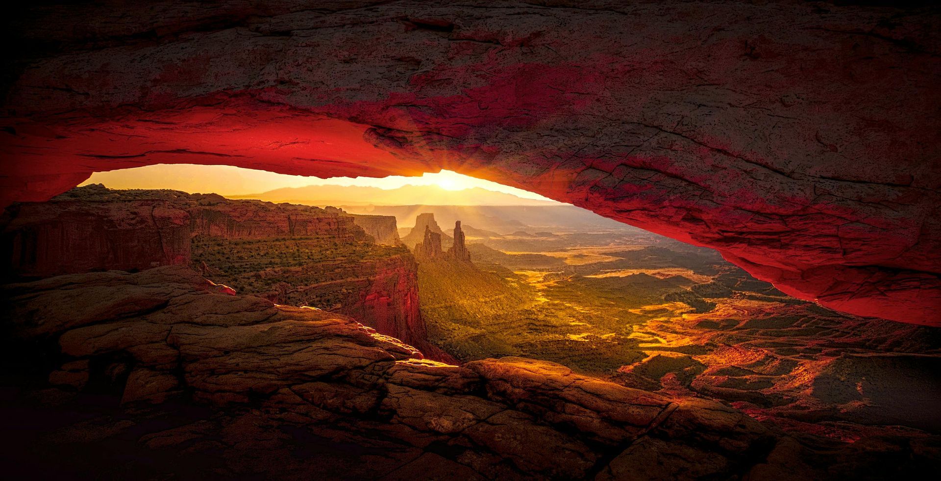 The sun is shining through the archway of the Grand Canyon.