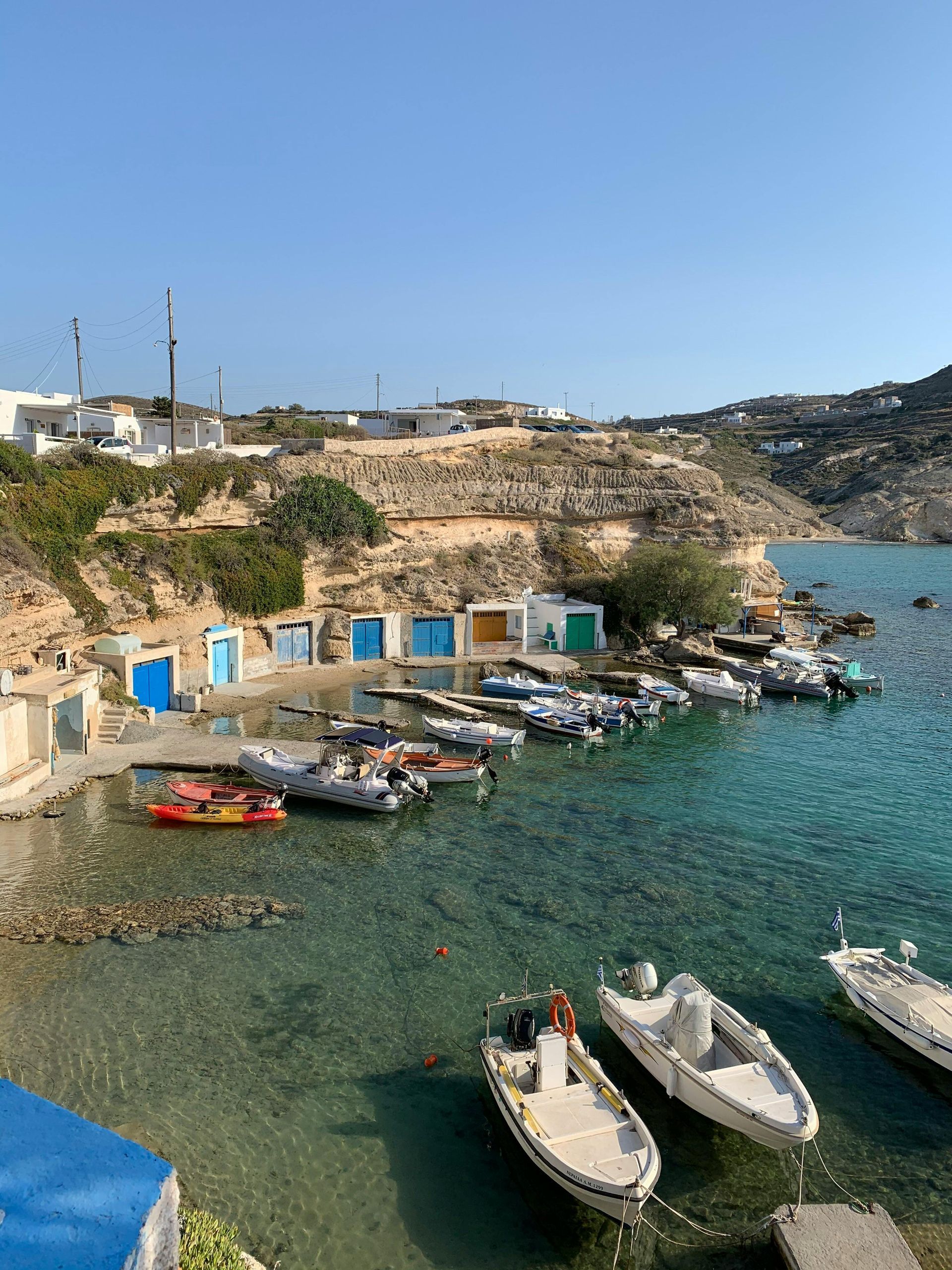A row of boats are docked in the fishing village of Mandrakia in Milos, Greece.