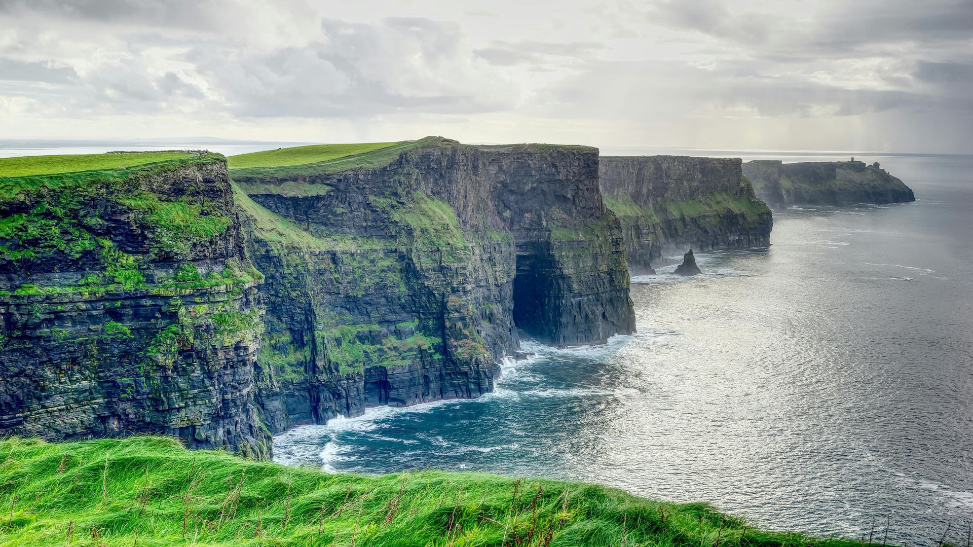 A view of the Cliffs of Moher overlooking a body of water in Ireland. 