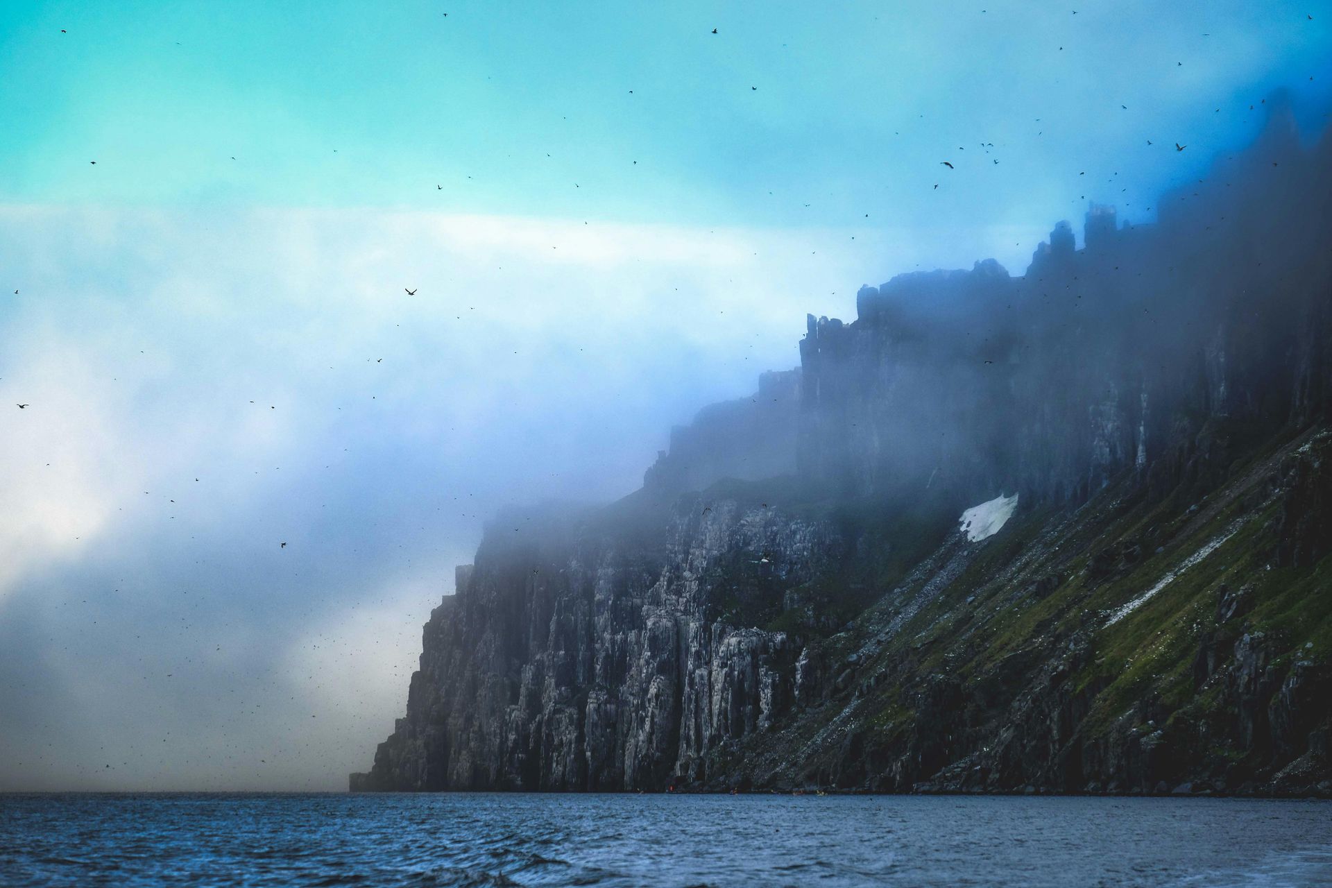 There is a mountain in the background of a fjord in Svalbard, Norway.