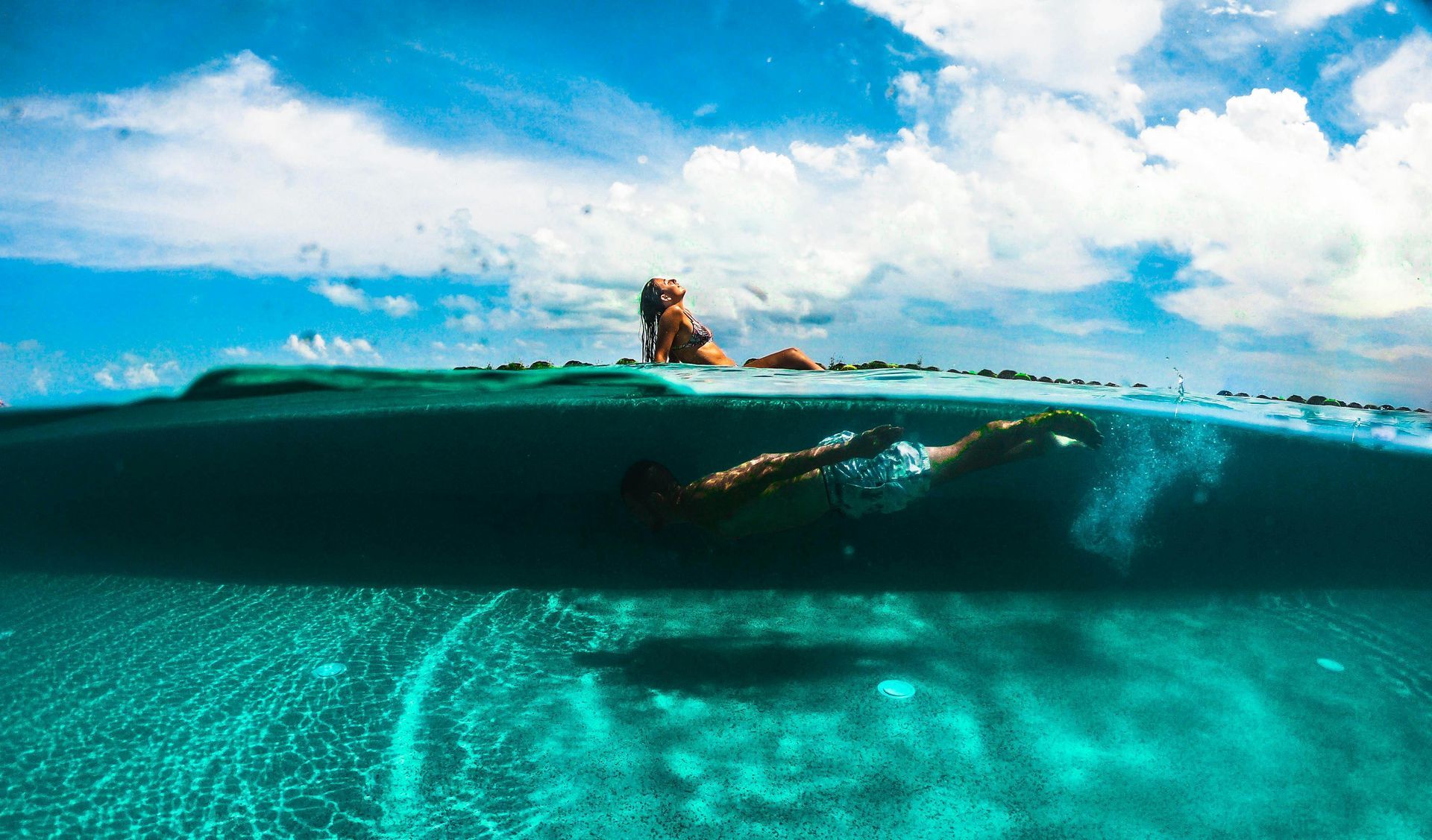 A woman is swimming underwater in a swimming pool in Cancun.