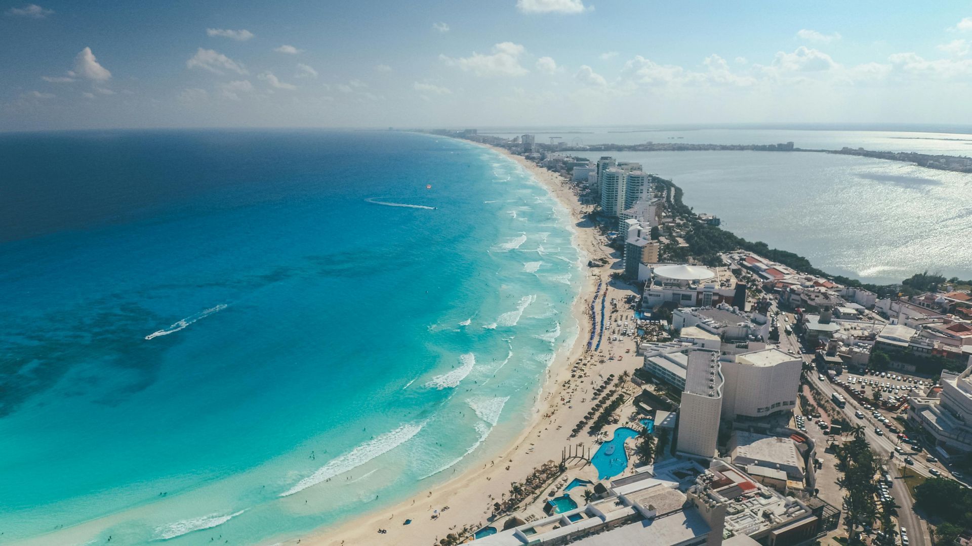 An aerial view of a beach with a city in the background in Cancun.