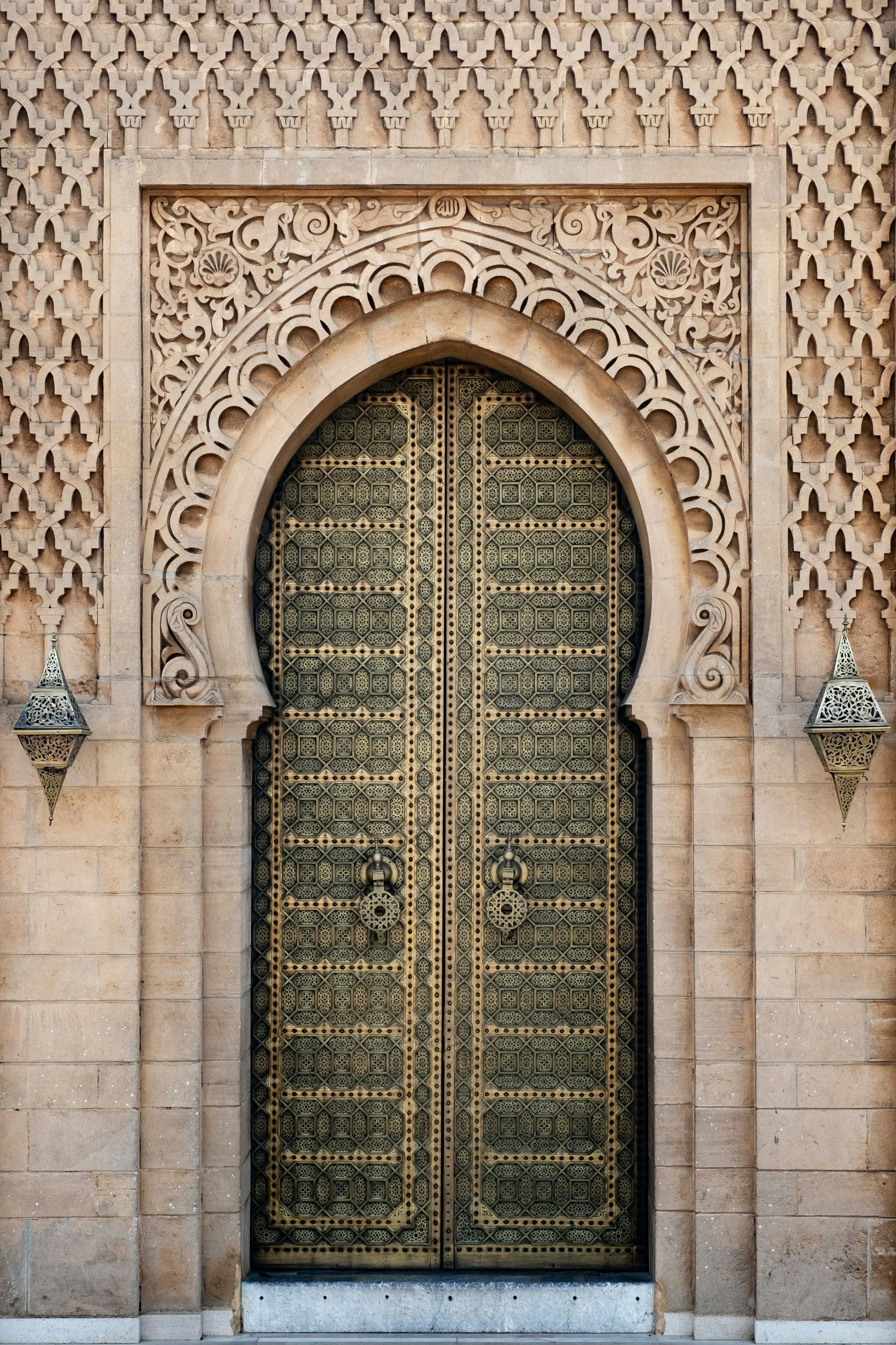 A door with arabic writing on it is on a Riad in Morocco.