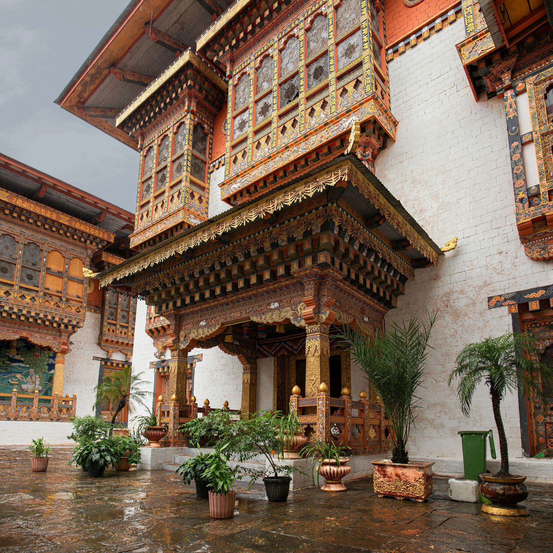 Punakha Dzong exterior with carved wood details and potted plants in Punakha, Bhutan.