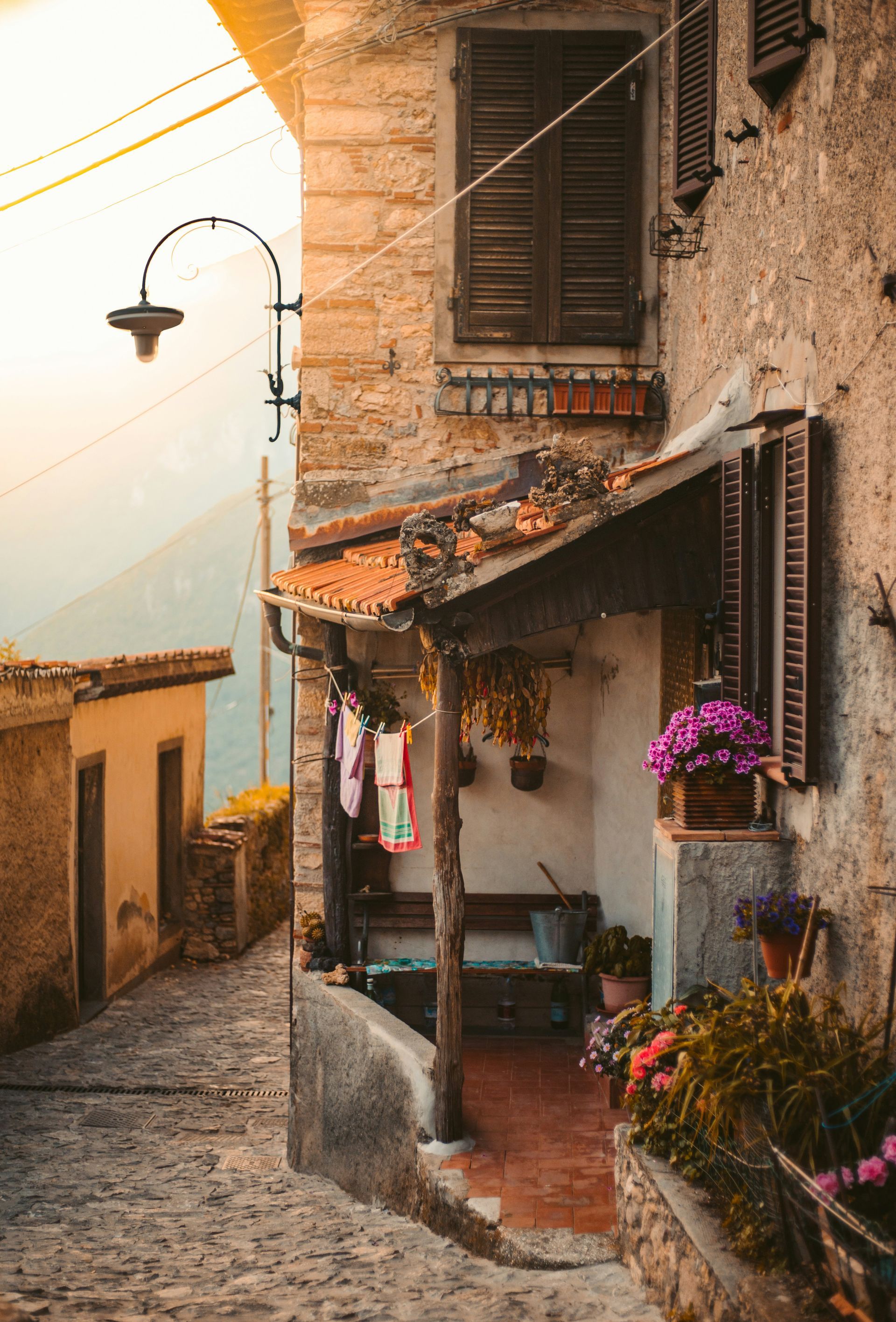A narrow alleyway between two buildings with flowers in front of them in Siena, Italy.